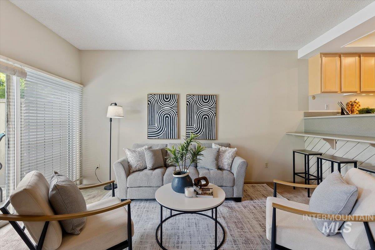 Open-concept living area featuring a vaulted ceiling and sliding glass door