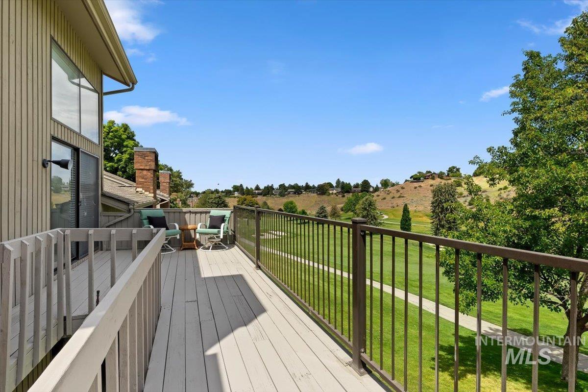 Expansive outdoor deck featuring wood-finish decking and dark metal railings