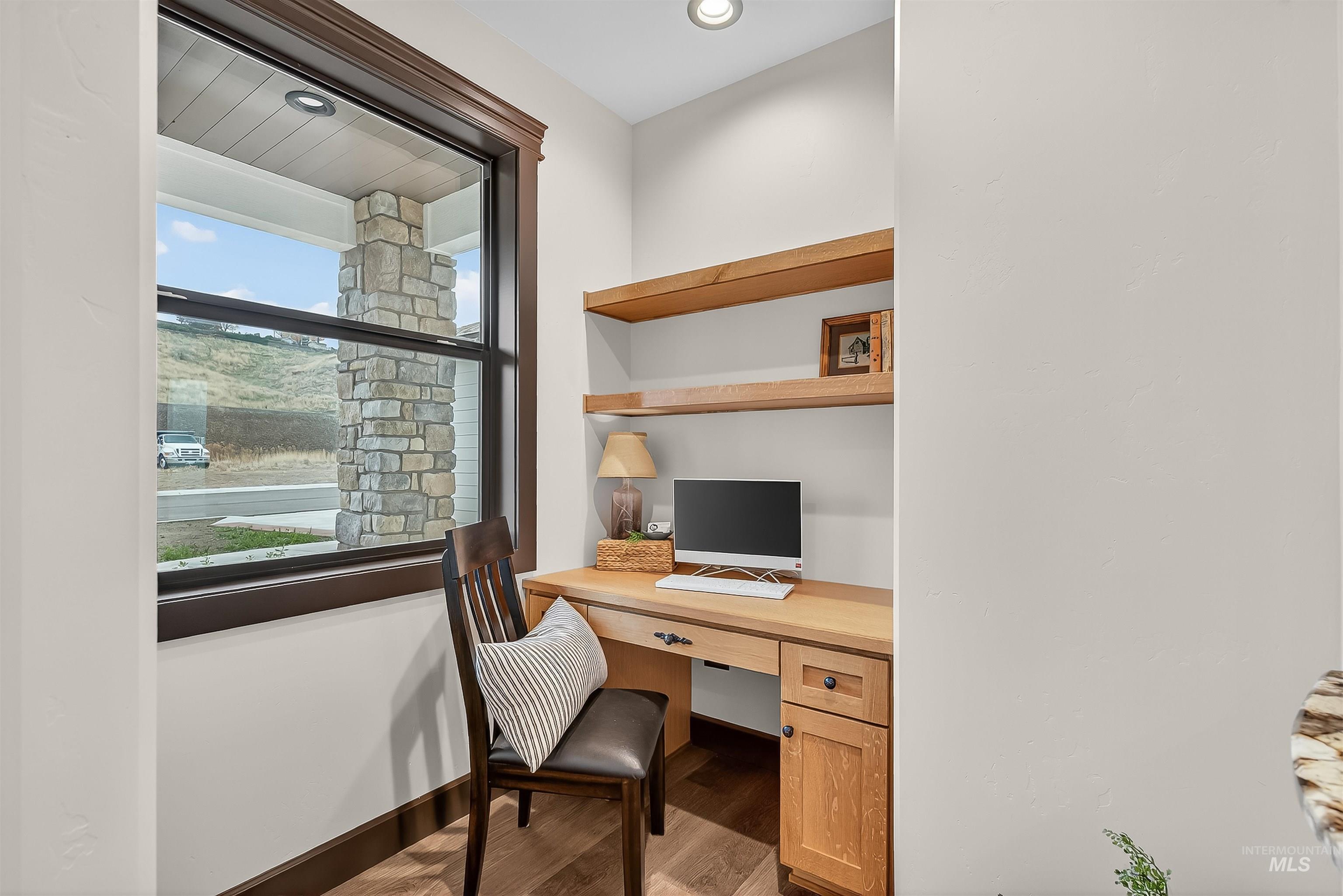 Office space with built in study area and light wood-style flooring