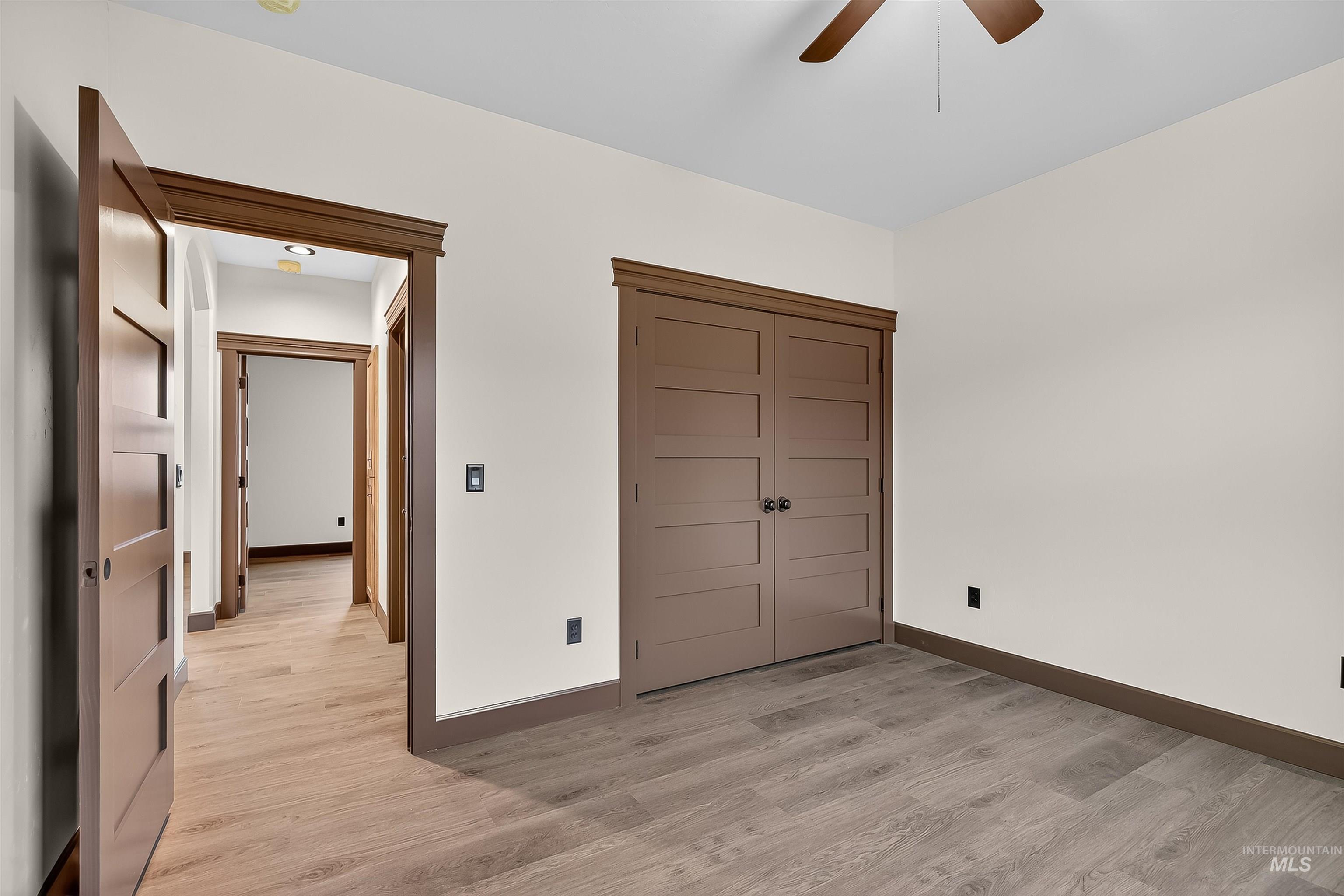 Unfurnished bedroom with light wood-style flooring, a closet, and ceiling fan