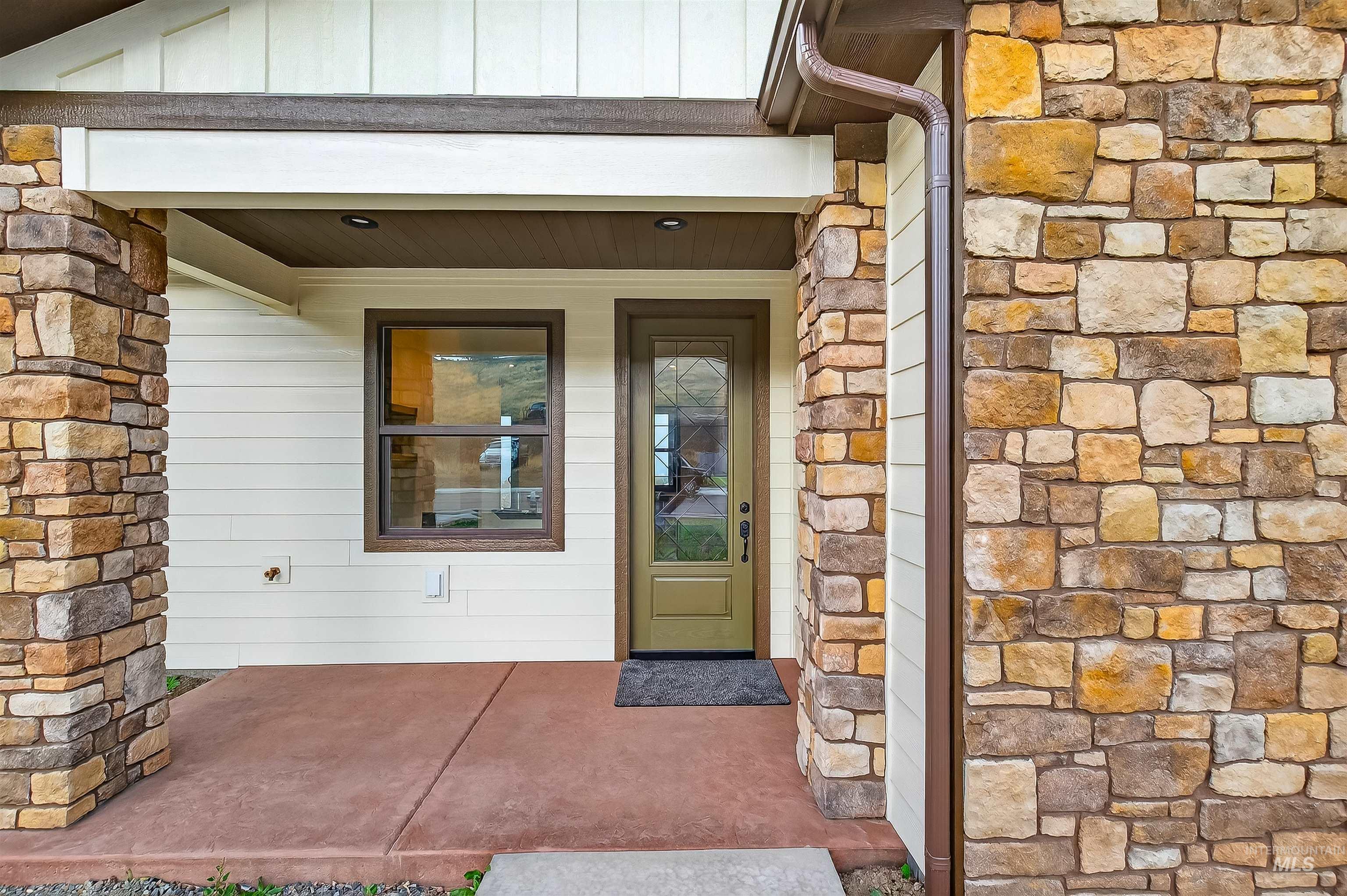 View of exterior entry featuring stone siding