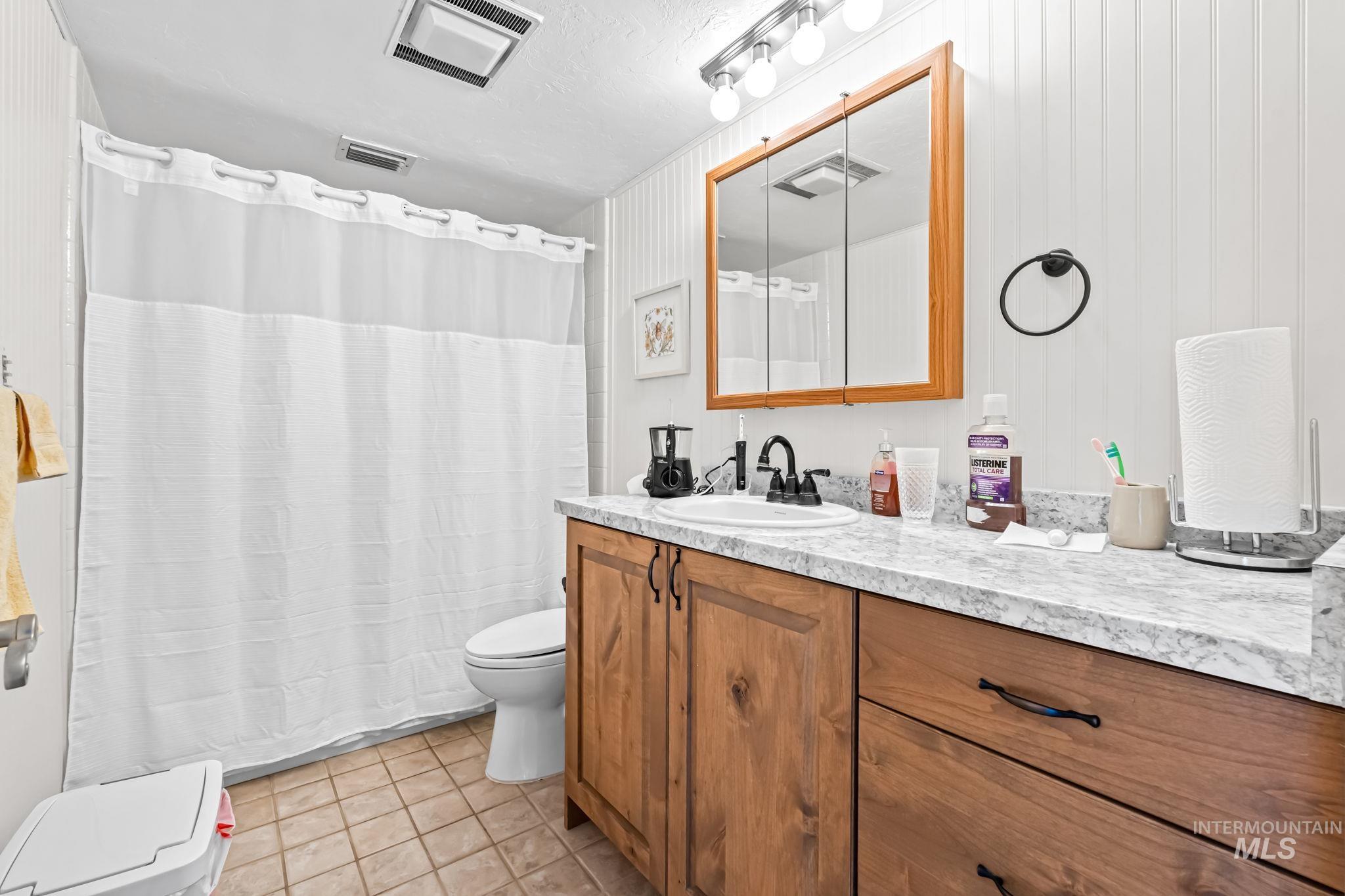 Bathroom featuring vanity, tile patterned floors, and a shower with curtain