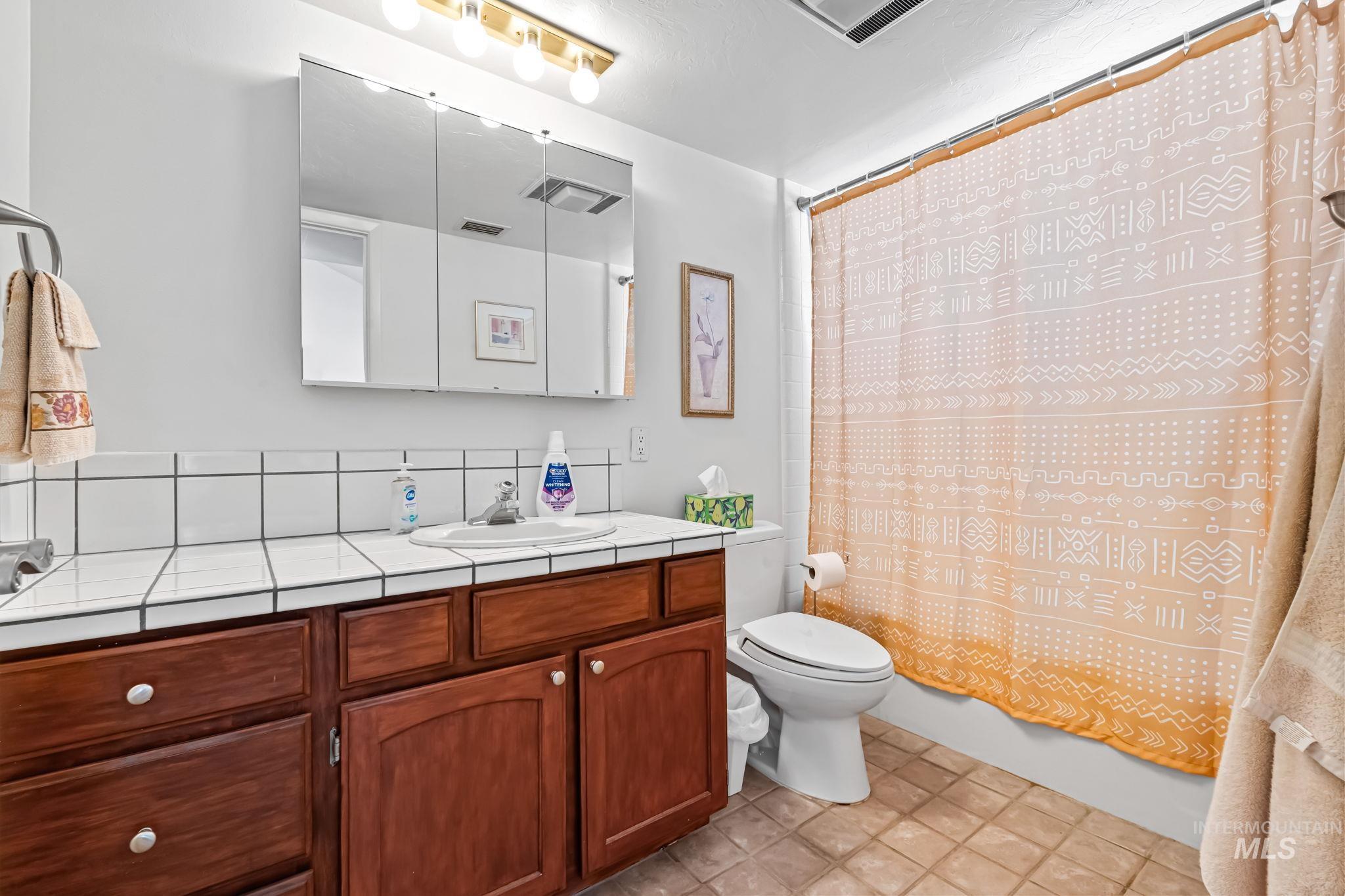 Bathroom featuring vanity and shower / bath combo