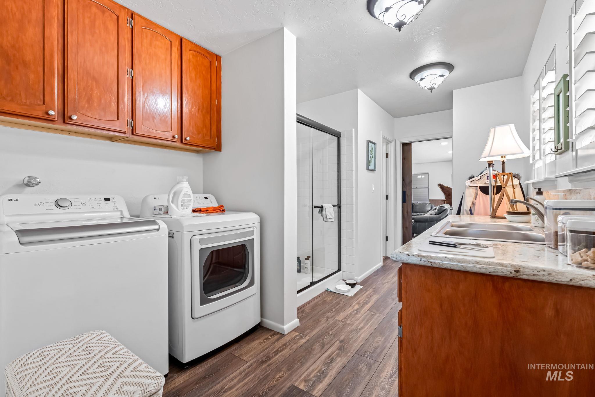 Washroom with separate washer and dryer and dark wood-style flooring