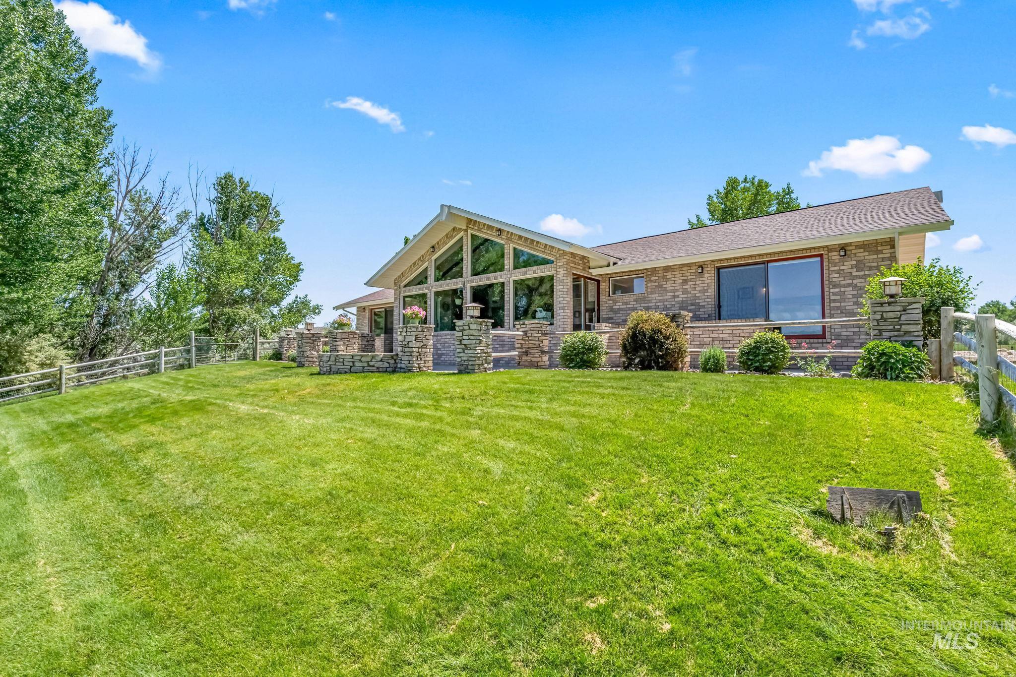 Back of house with a fenced backyard and brick siding