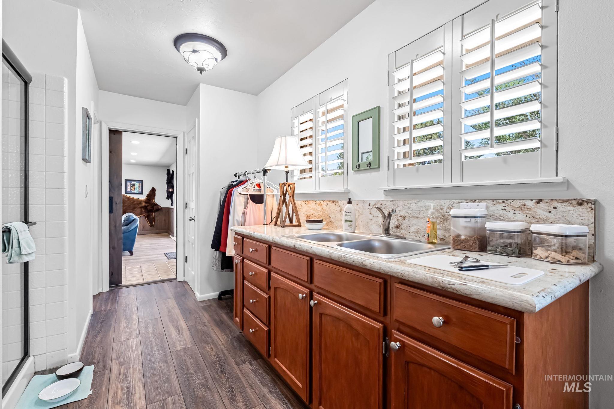 Kitchen with dark wood-type flooring, light countertops, and brown cabinets