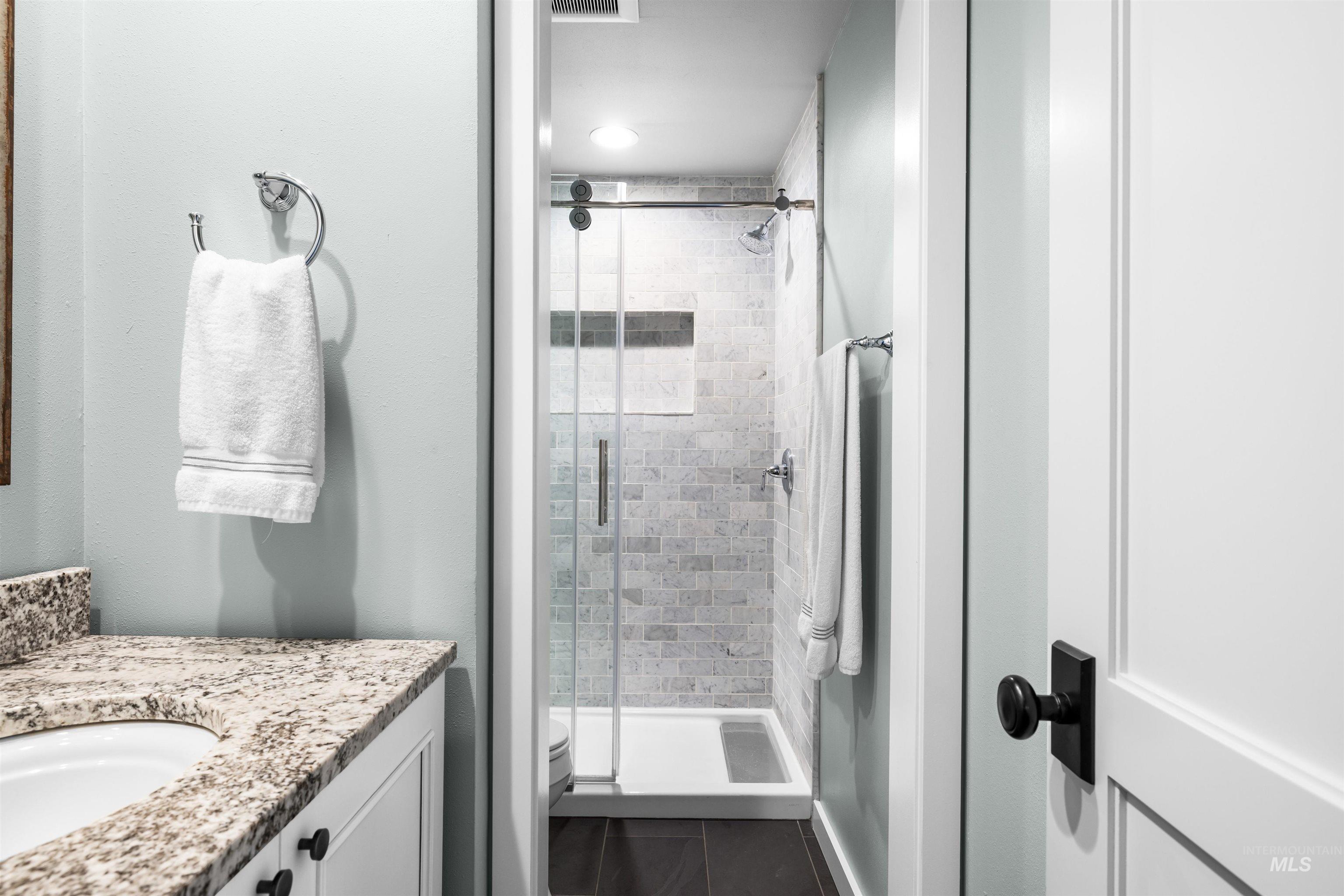 Bathroom with a stall shower, vanity, and tile patterned floors