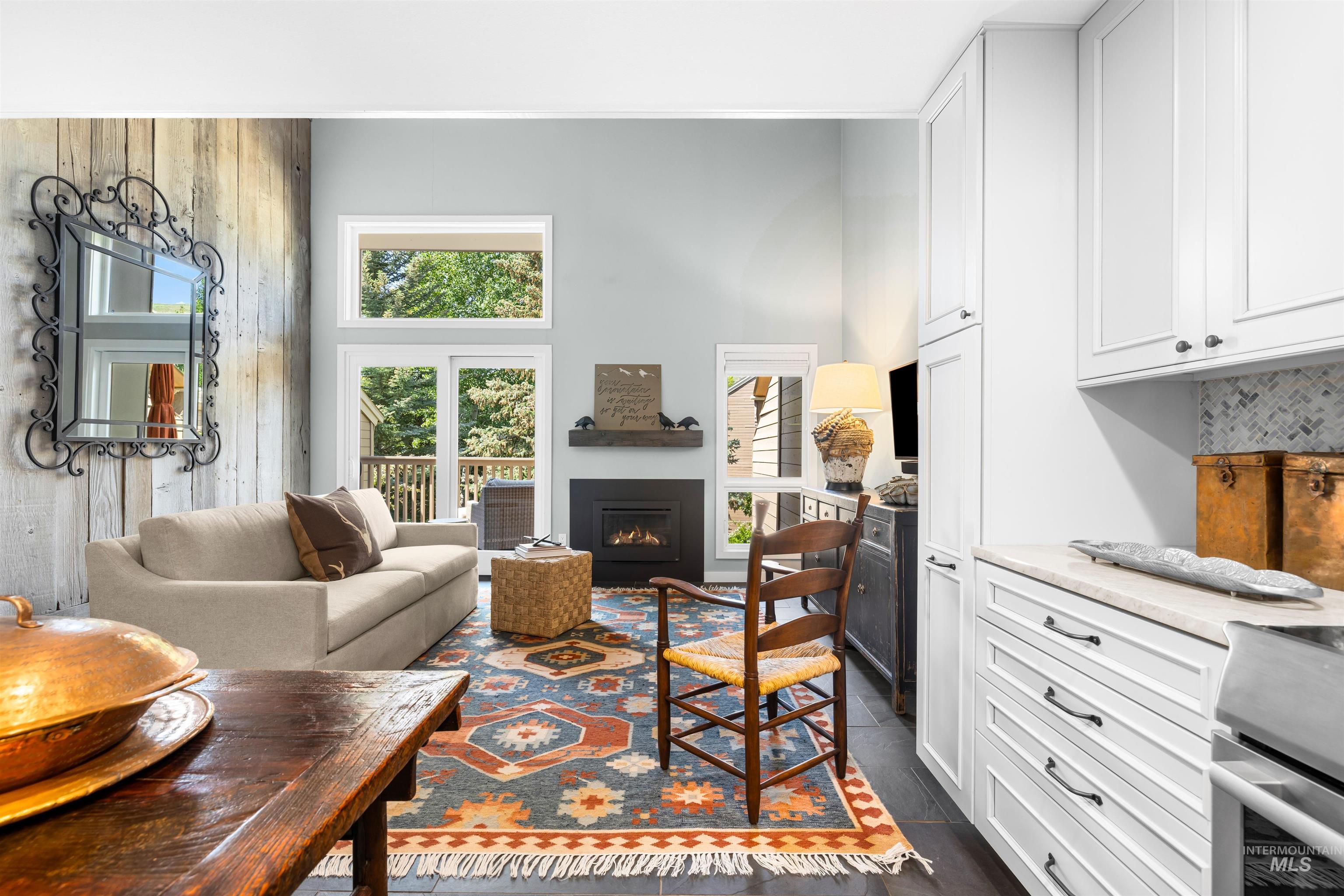 Living area with a lit fireplace and a towering ceiling