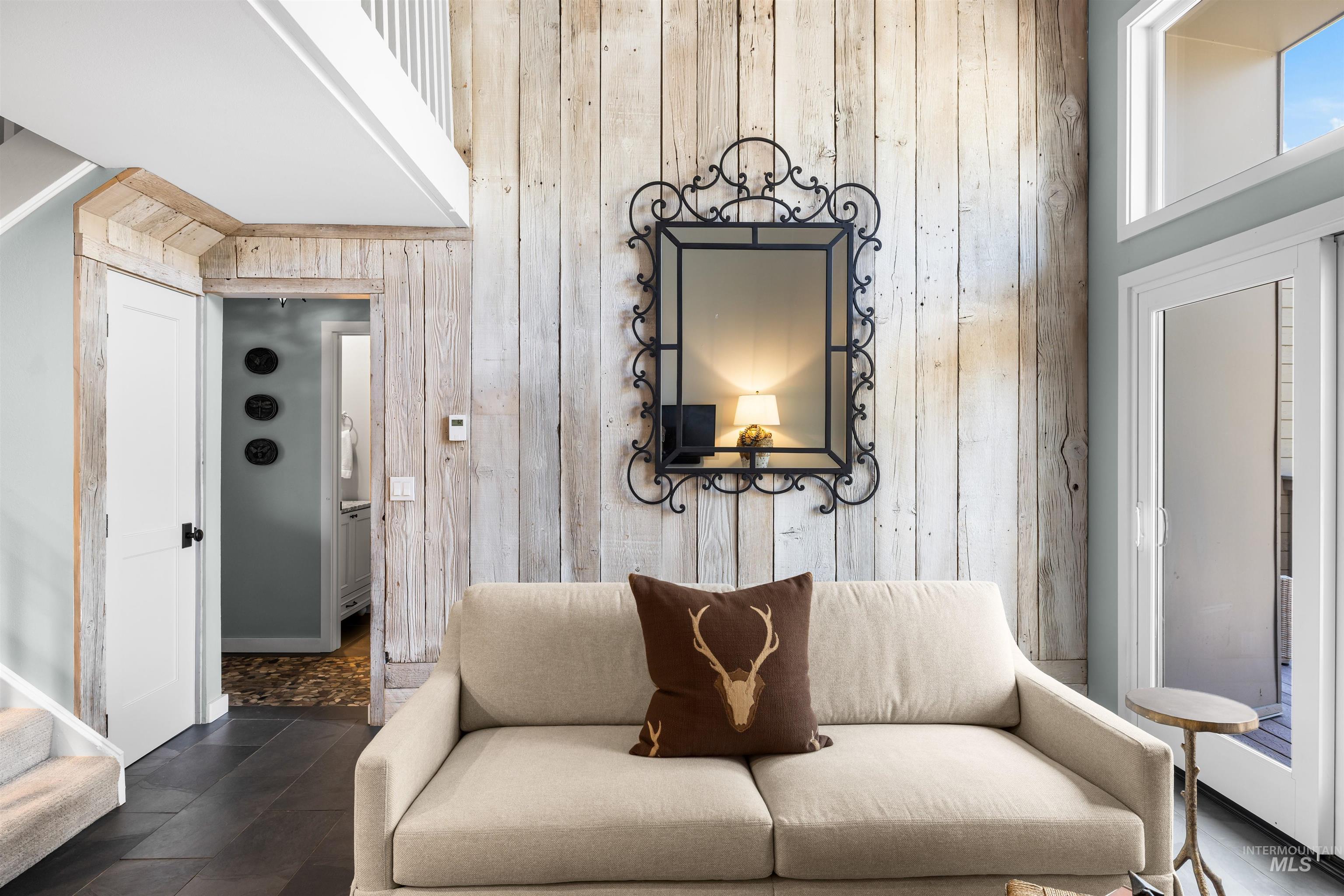 Living room featuring wood walls, a high ceiling, and stairway