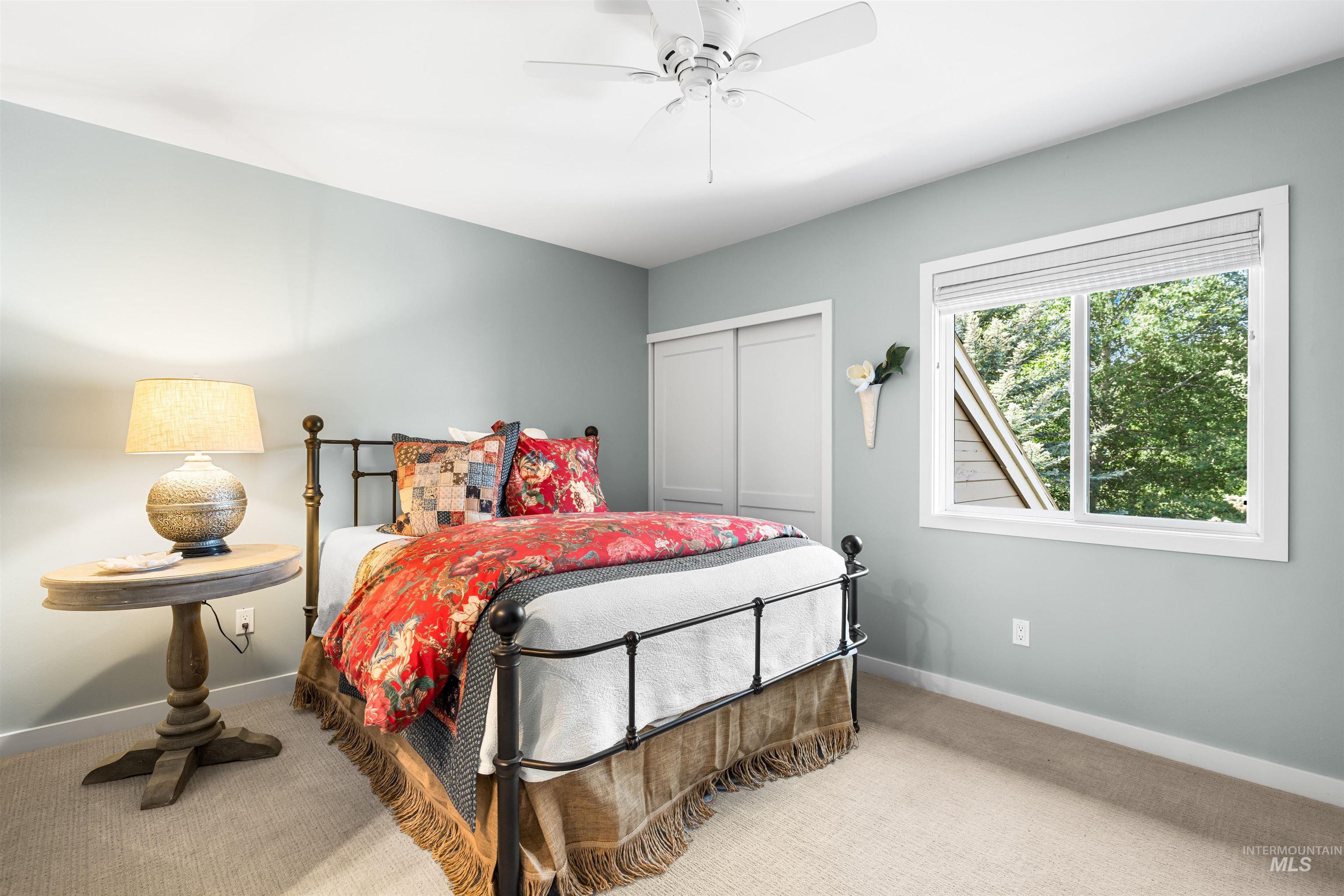 Carpeted bedroom featuring a closet and a ceiling fan