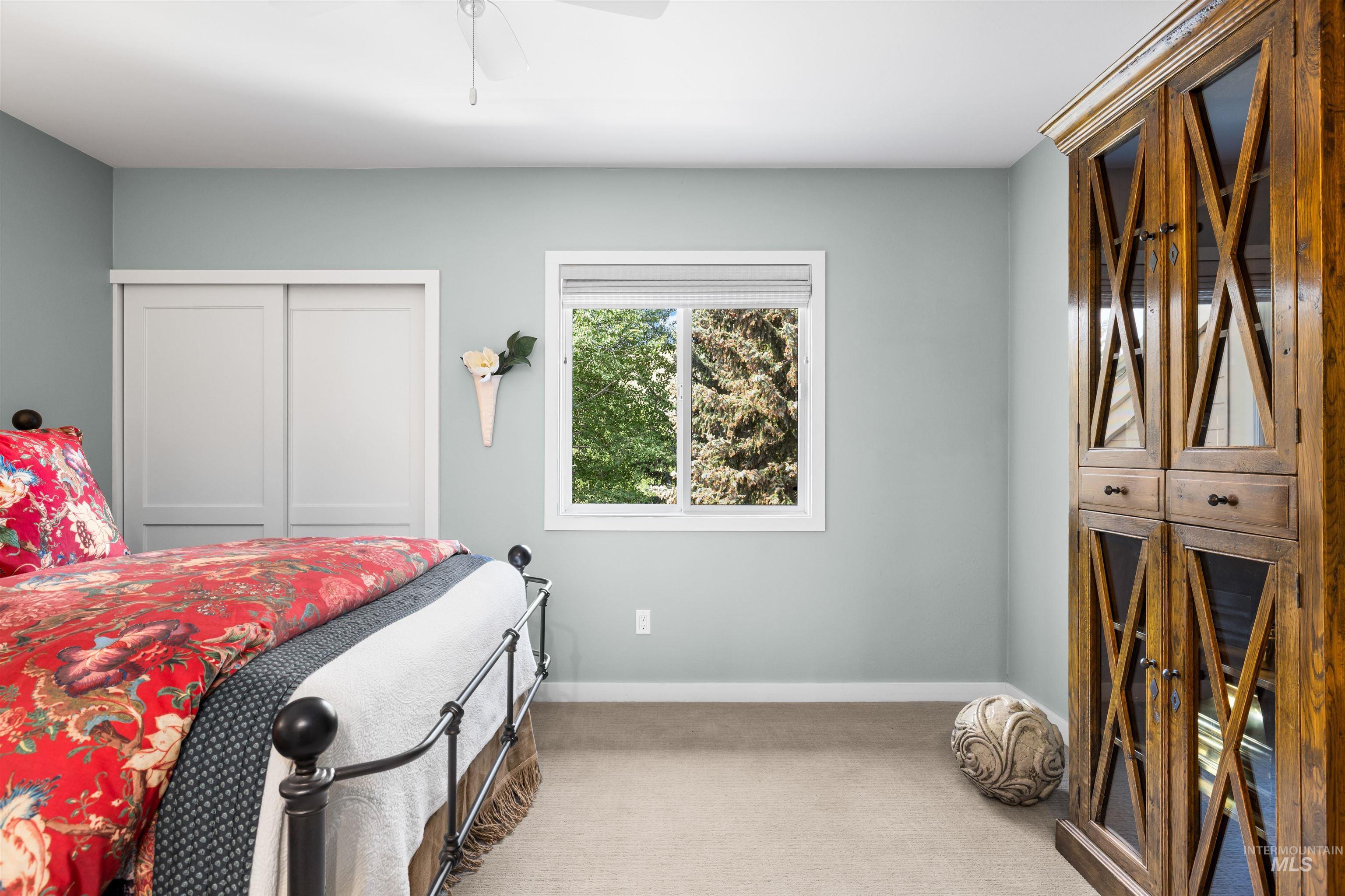 Carpeted bedroom with a closet and ceiling fan