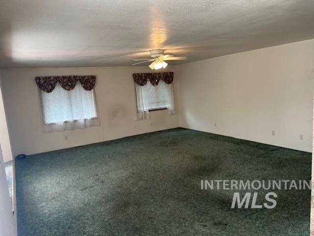 Unfurnished room with carpet flooring, ceiling fan, and a textured ceiling