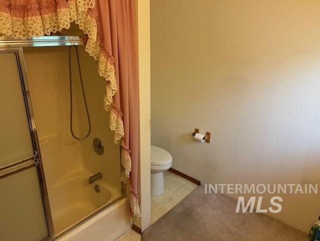 Full bath with shower / bath combination with glass door and toilet