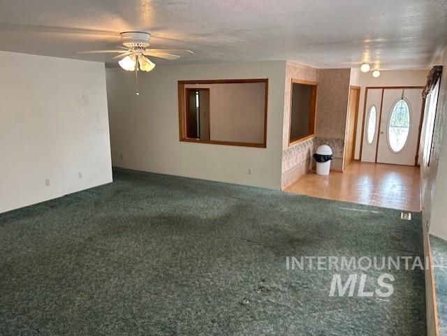 Unfurnished living room with carpet floors and ceiling fan