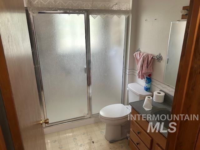 Full bathroom featuring vanity, a shower stall, and light floors