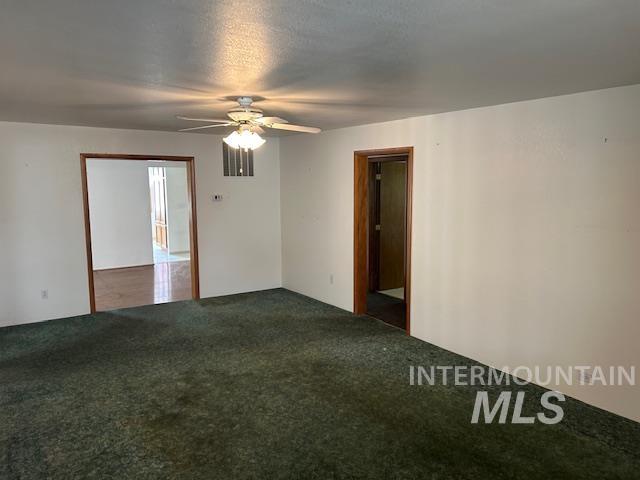 Spare room featuring ceiling fan, carpet flooring, and a textured ceiling