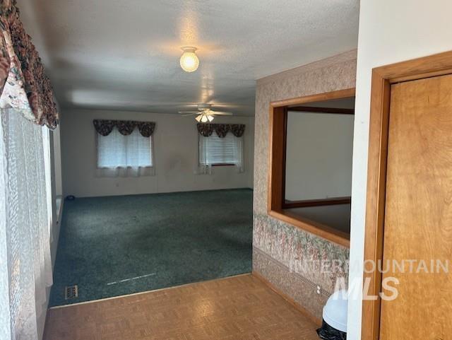 Carpeted empty room with a ceiling fan
