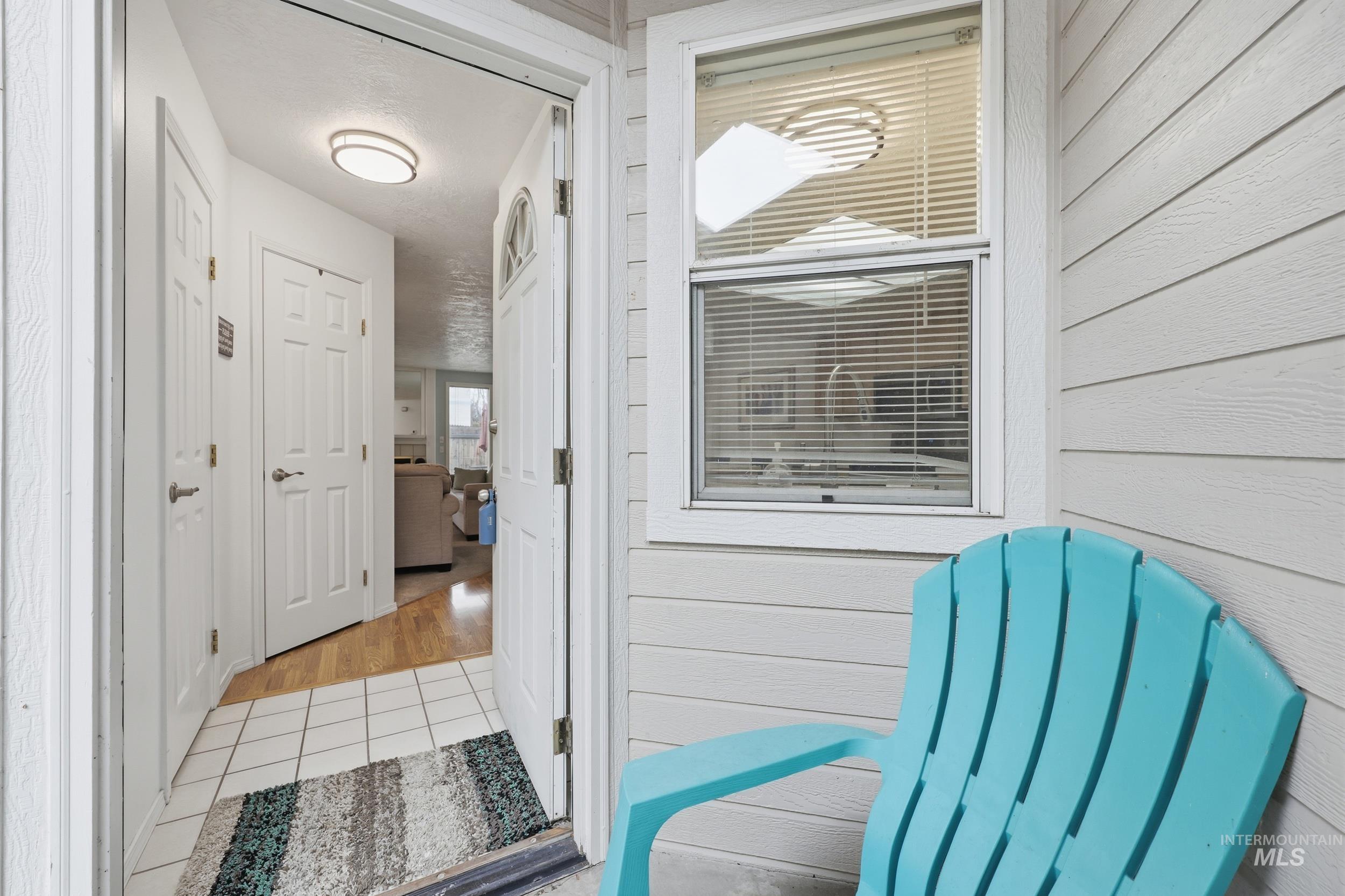 Corridor featuring light tile patterned floors and wood walls