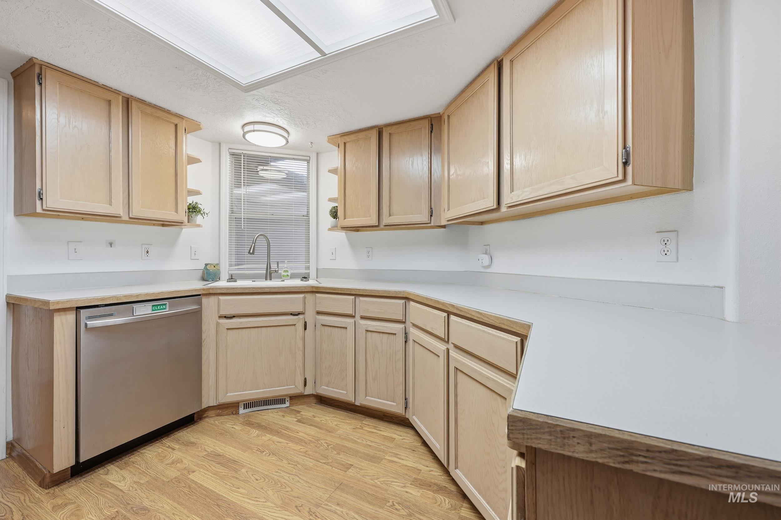 Kitchen featuring light brown cabinets, open shelves, and light countertops