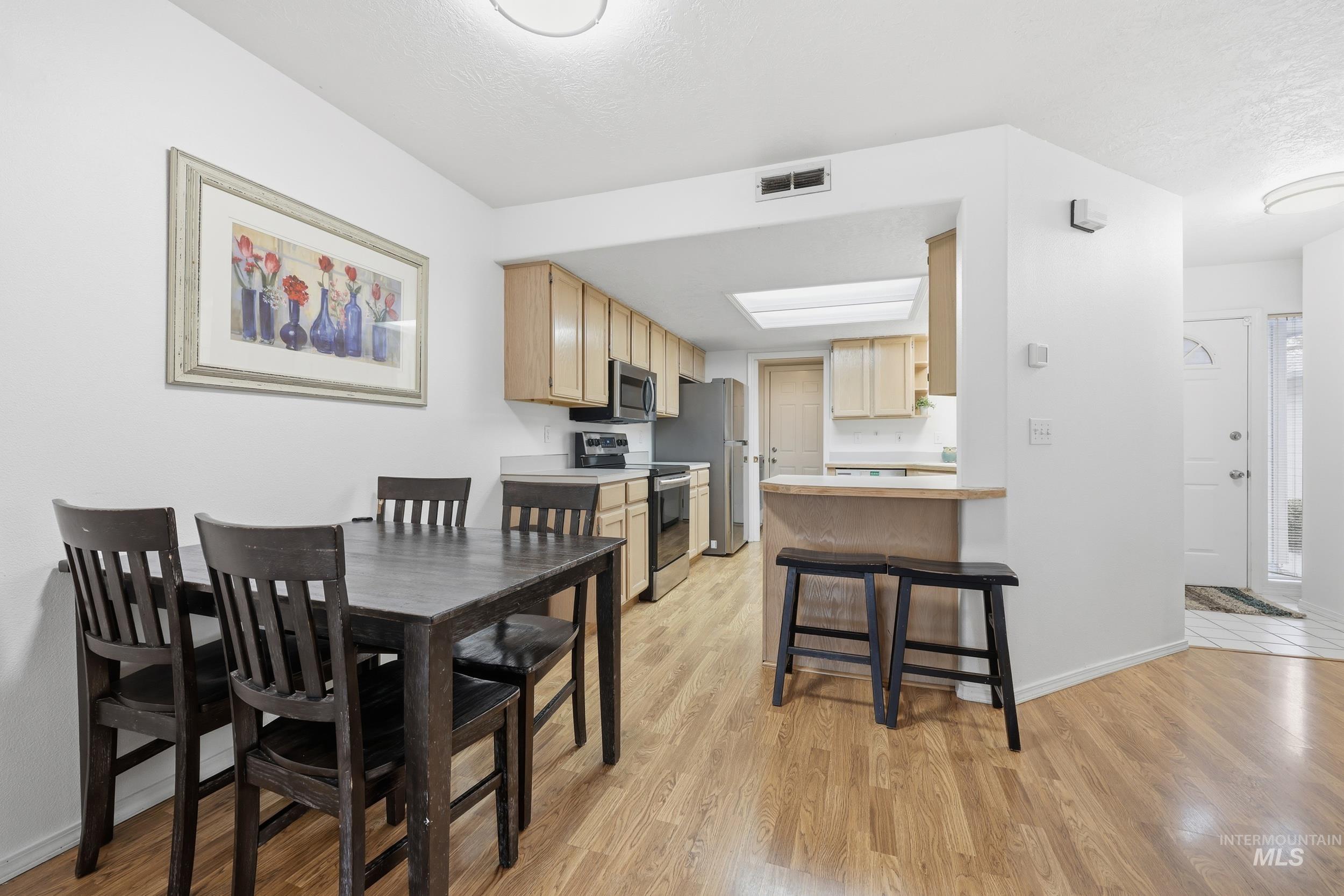 Dining space with baseboards and light wood-type flooring