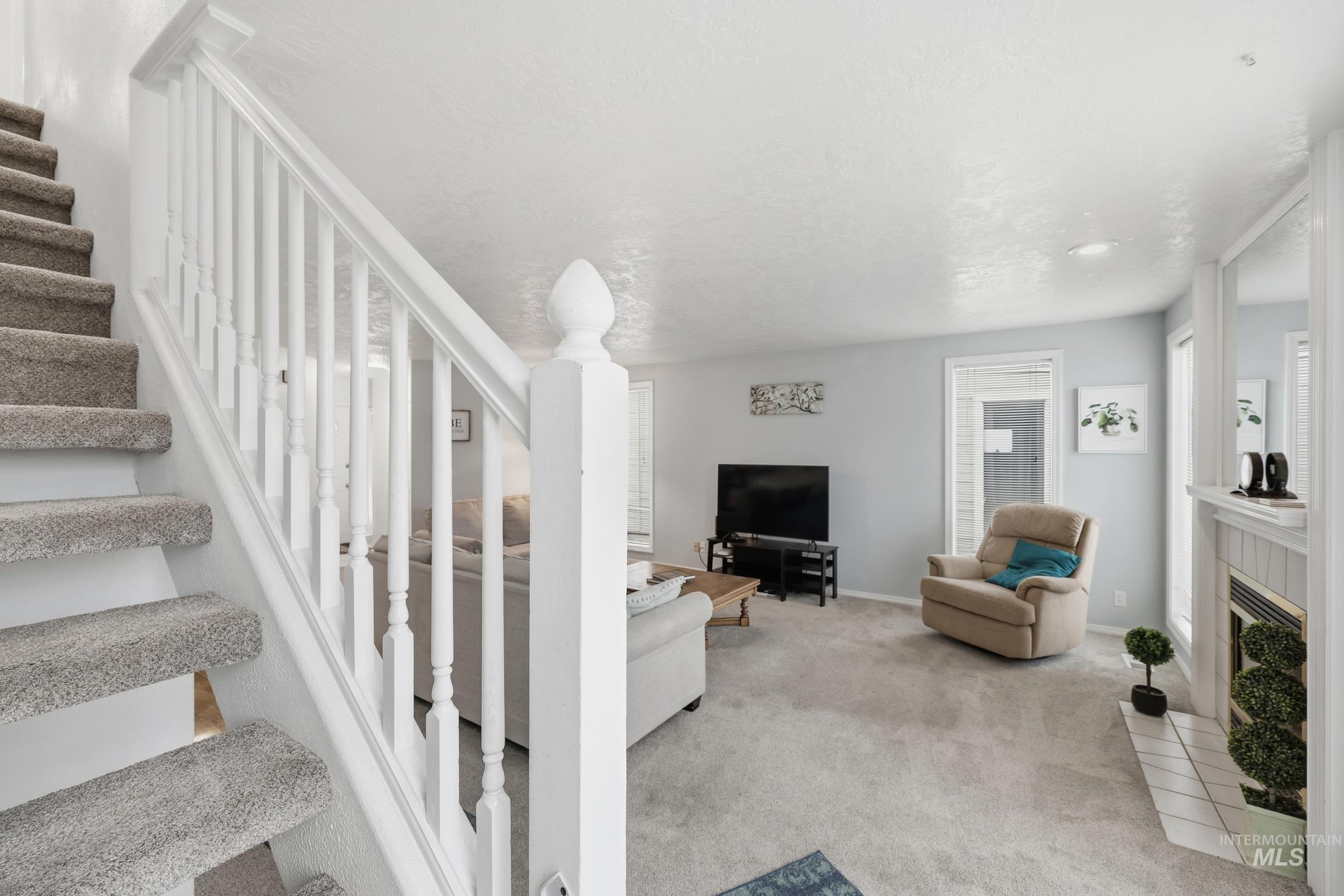 Stairs with carpet flooring and a tile fireplace