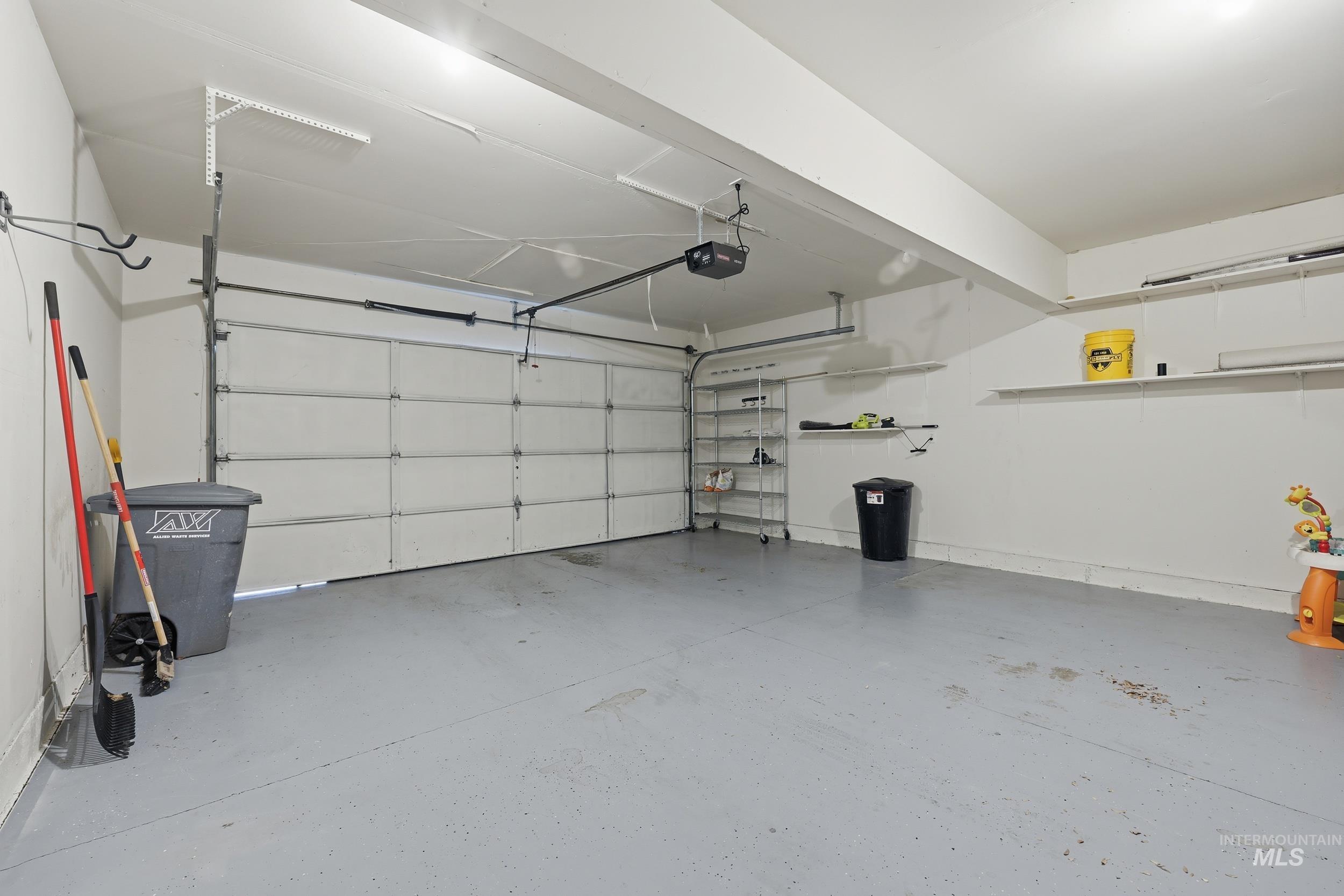 Garage with a garage door opener and baseboards