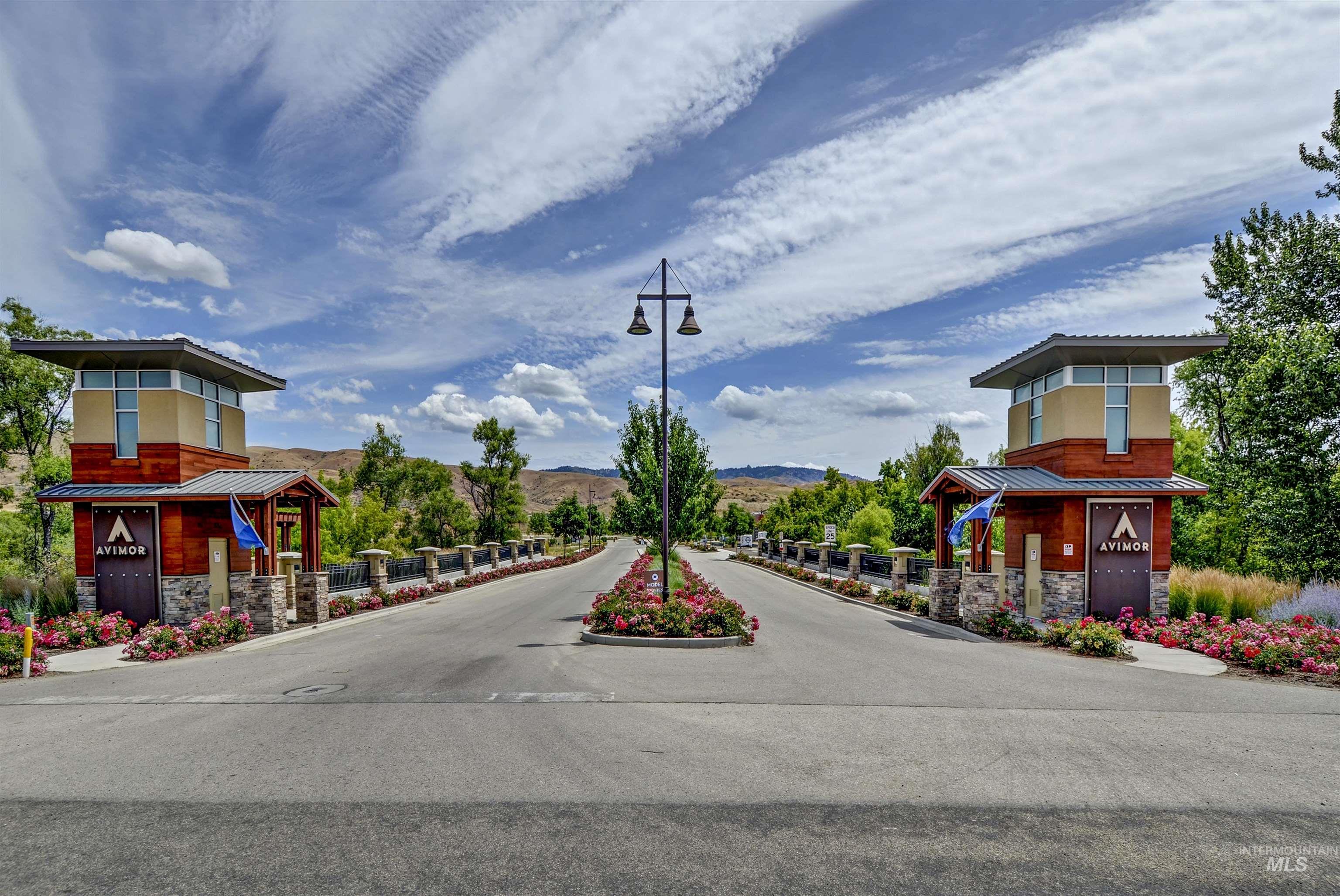View of asphalt street featuring street lighting, a mountain view, and curbs