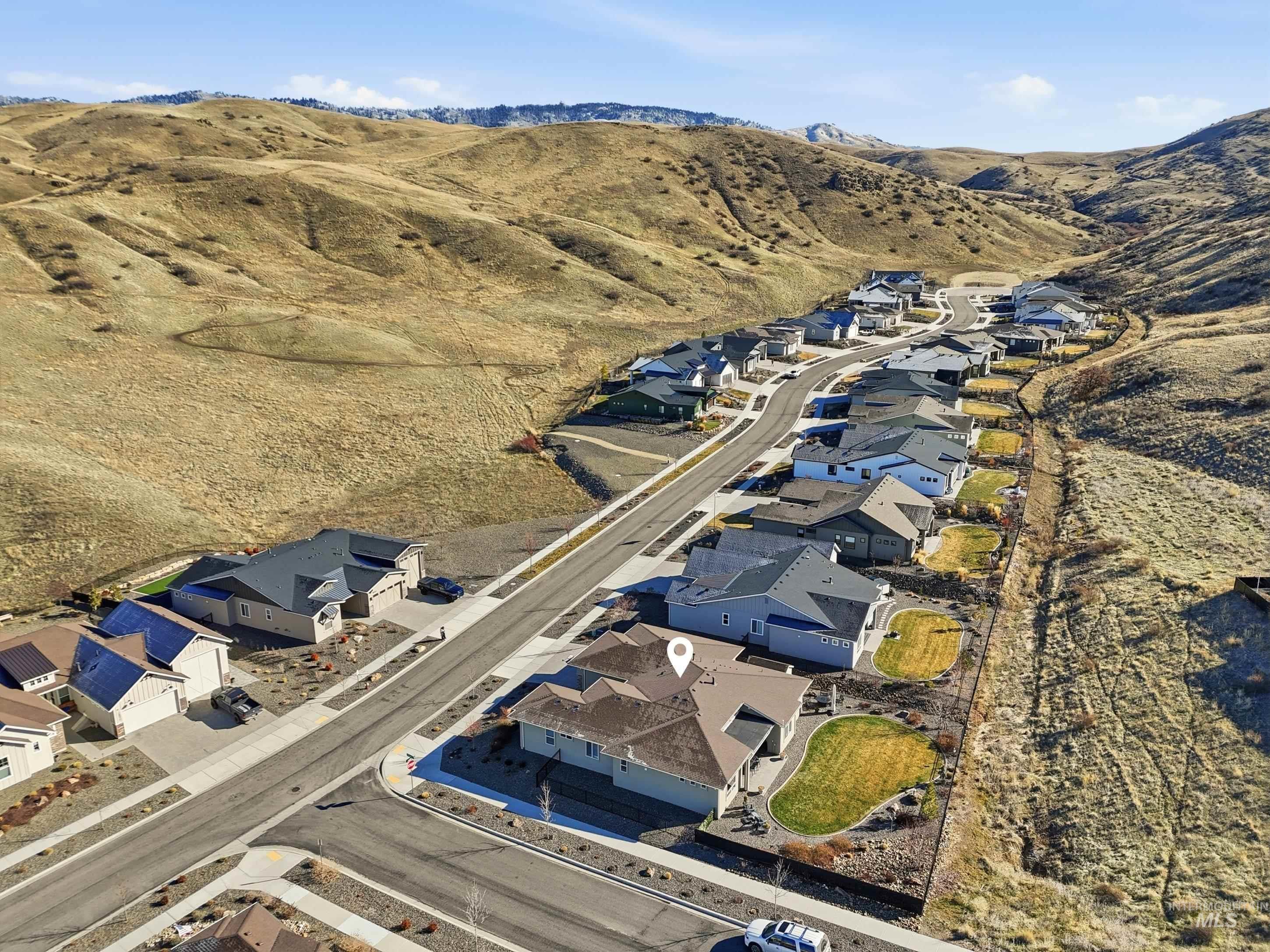 Aerial view of property and surrounding area with nearby suburban area and a mountainous background