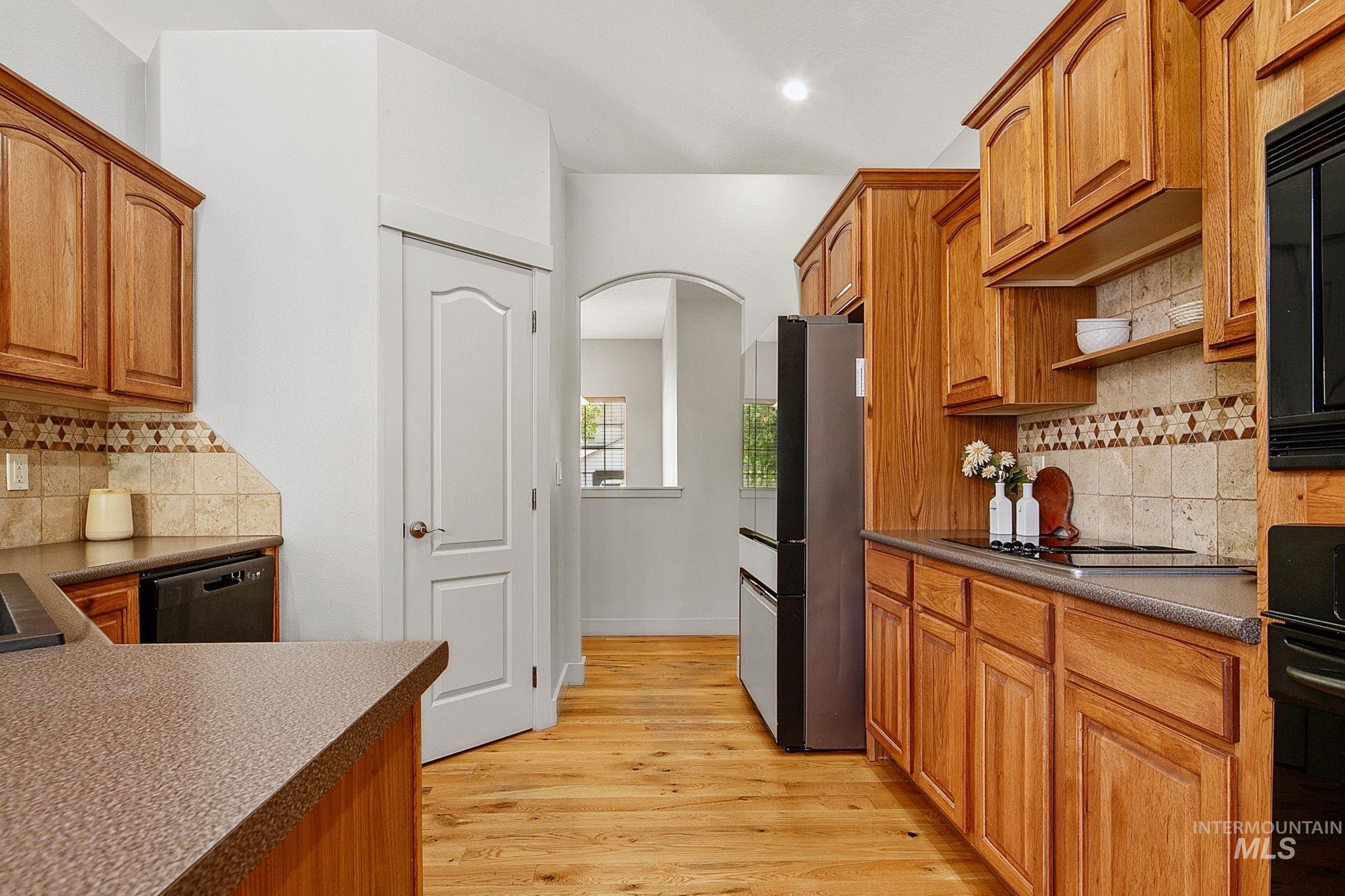 Kitchen featuring wood cabinetry, stone-look countertops, and a tiled backsplash