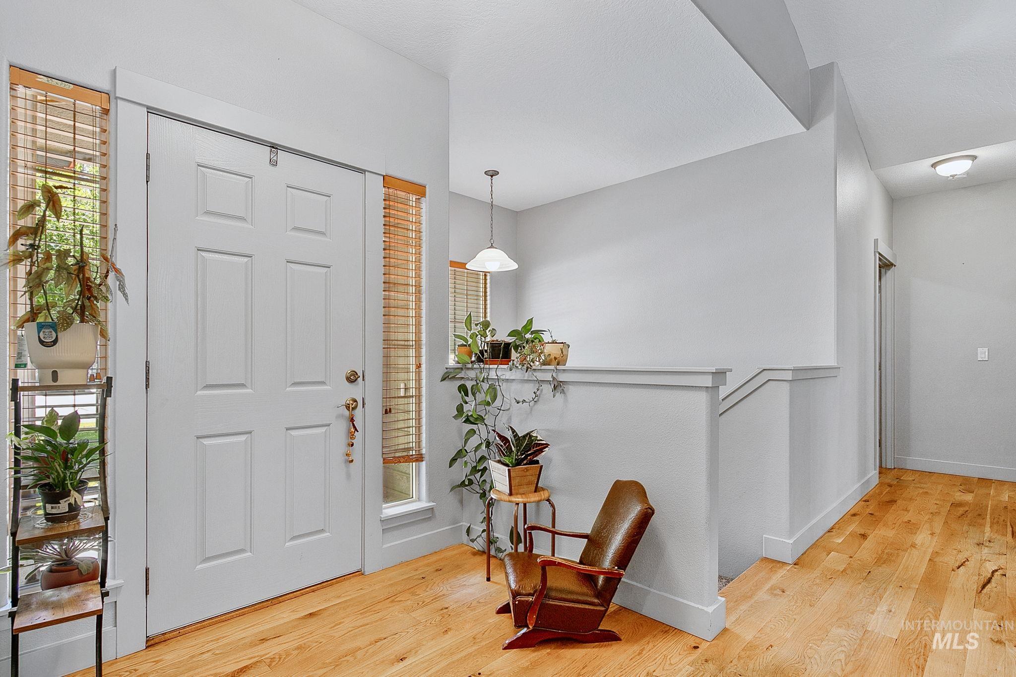 Entryway featuring a paneled door with sidelights, wood-finish flooring, and a neutral color palette