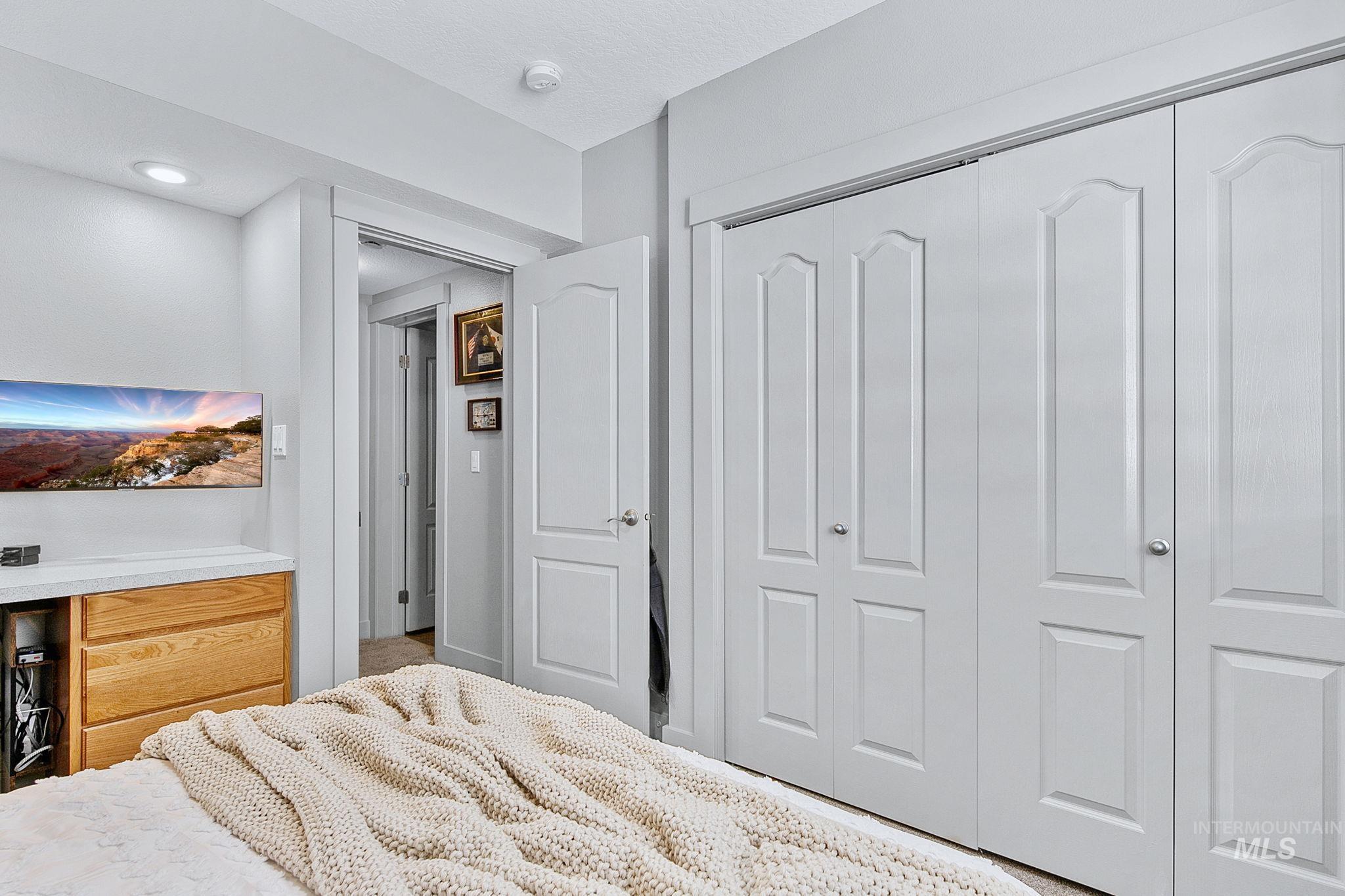 Bedroom featuring bi-fold closet doors, recessed lighting, and wood-finish cabinetry with a light-colored countertop