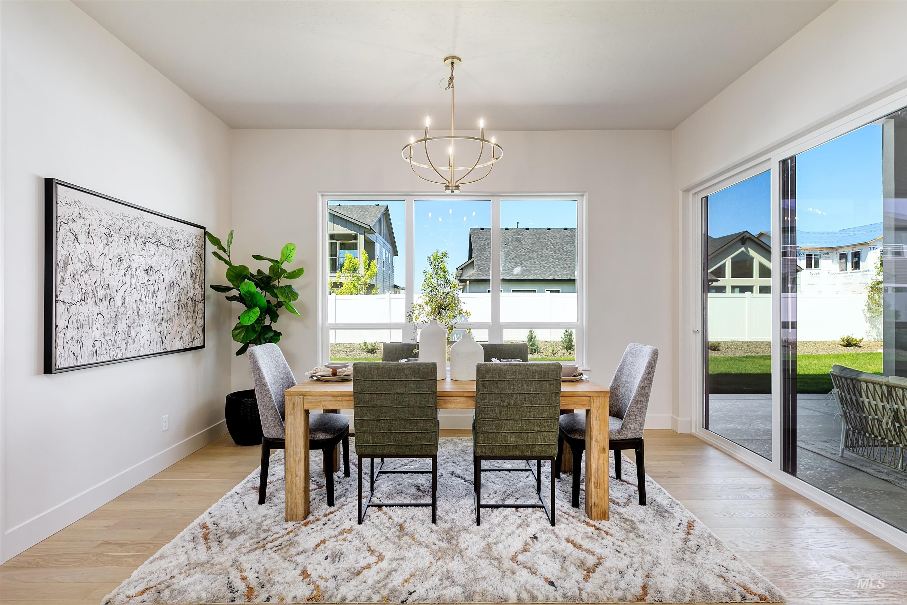 Dining area featuring a chandelier, healthy amount of natural light, and light wood-style floors