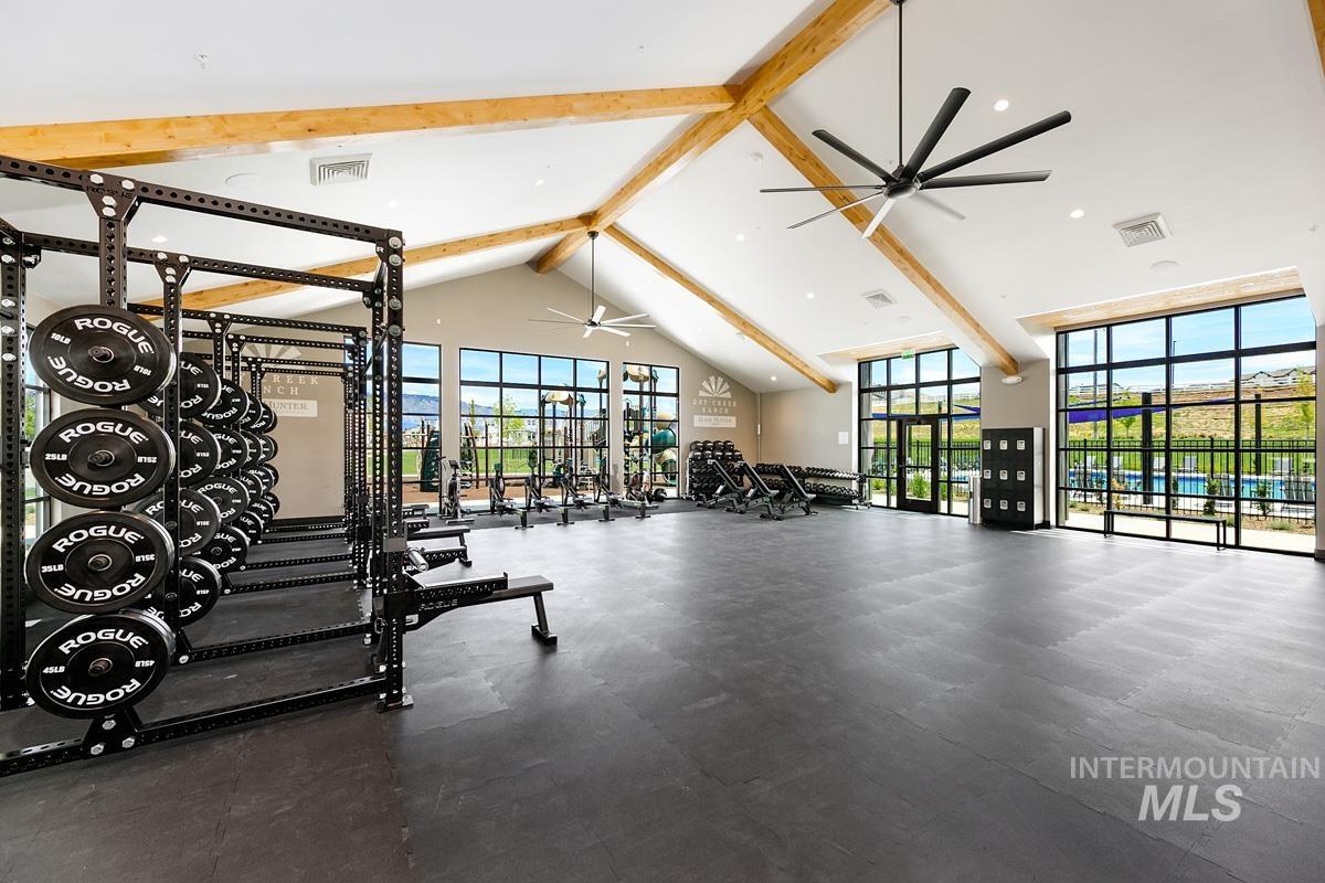 Gym with a ceiling fan, beam ceiling, and high vaulted ceiling