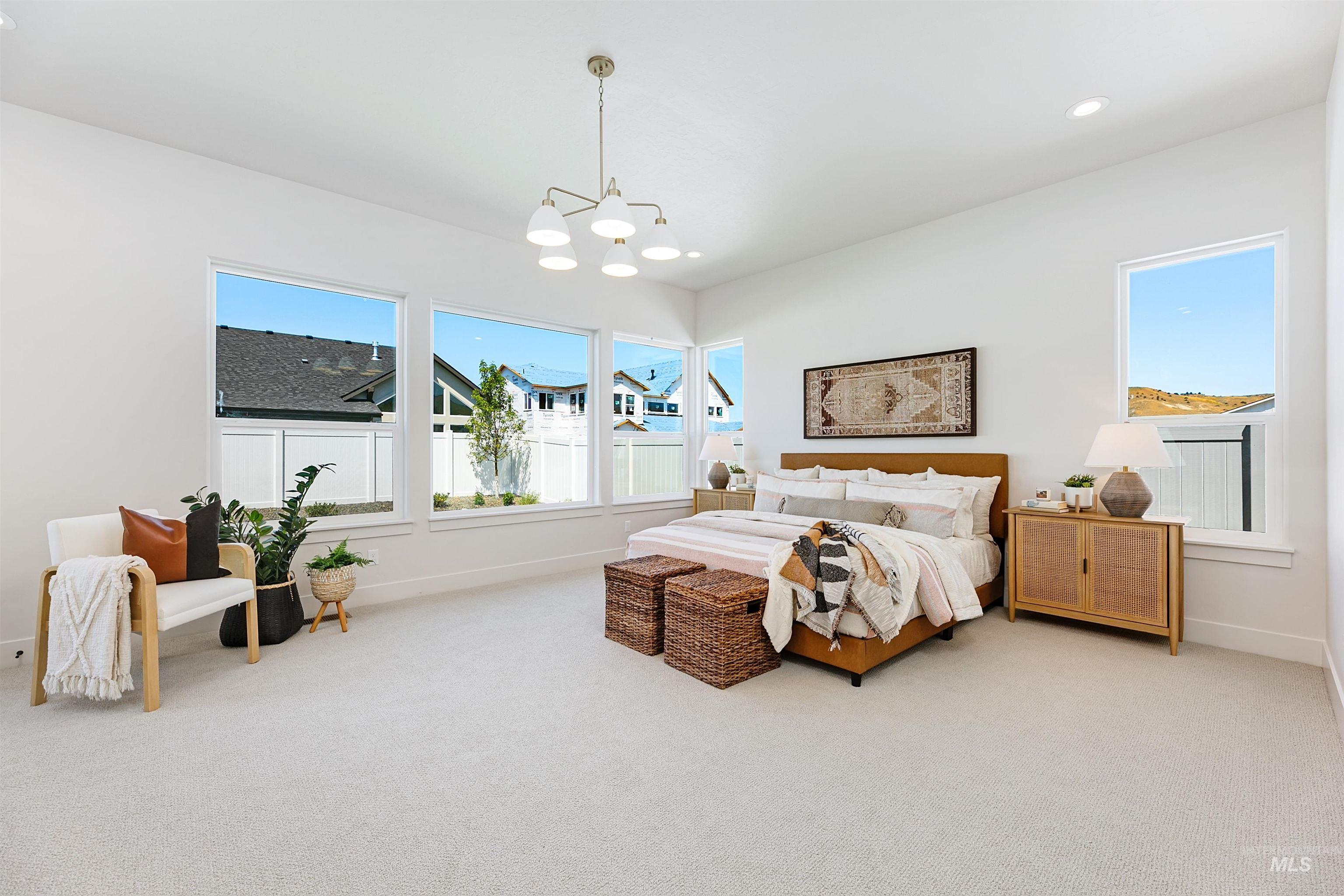 Carpeted bedroom with a chandelier and recessed lighting