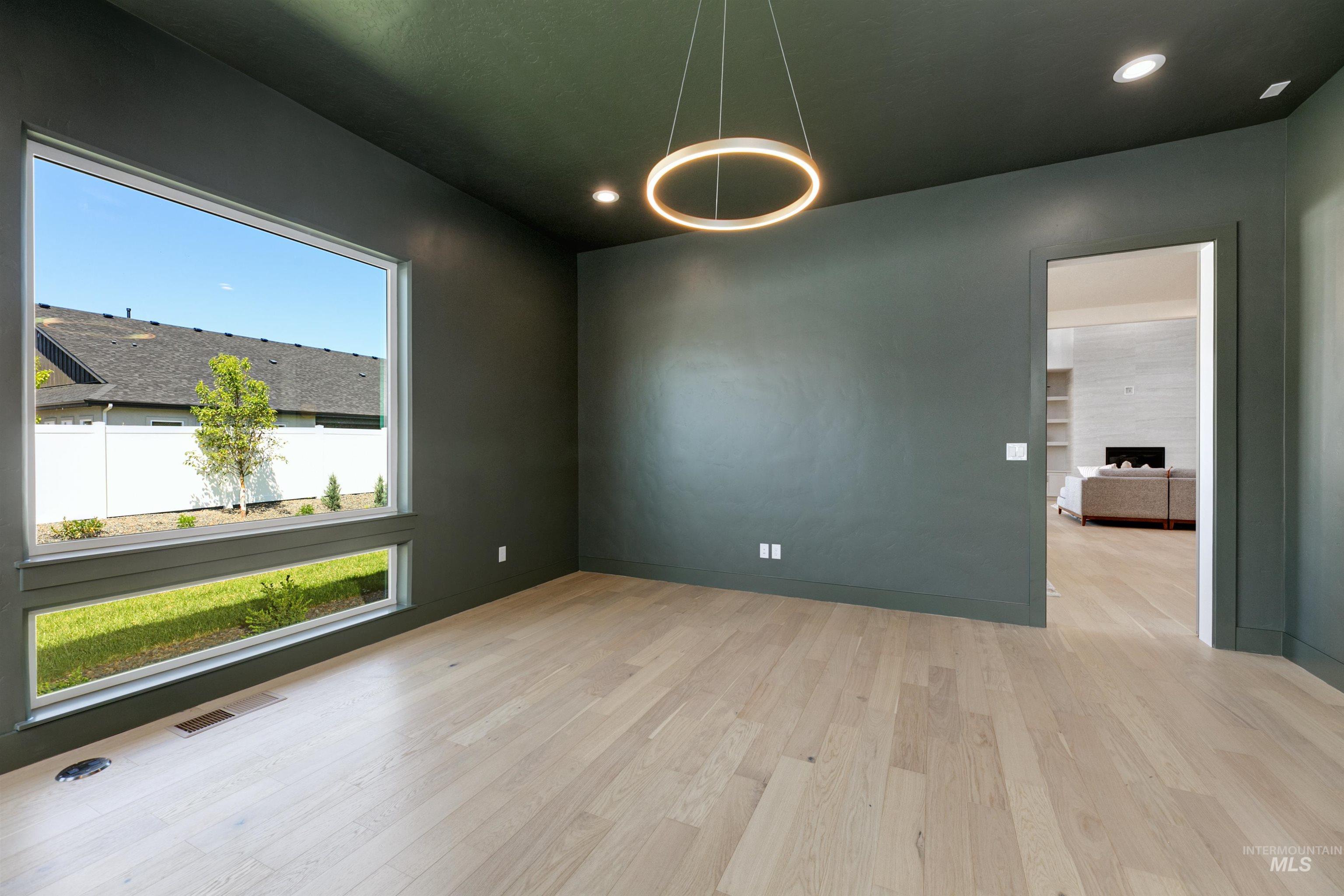 Unfurnished room featuring wood finished floors, a tiled fireplace, and recessed lighting