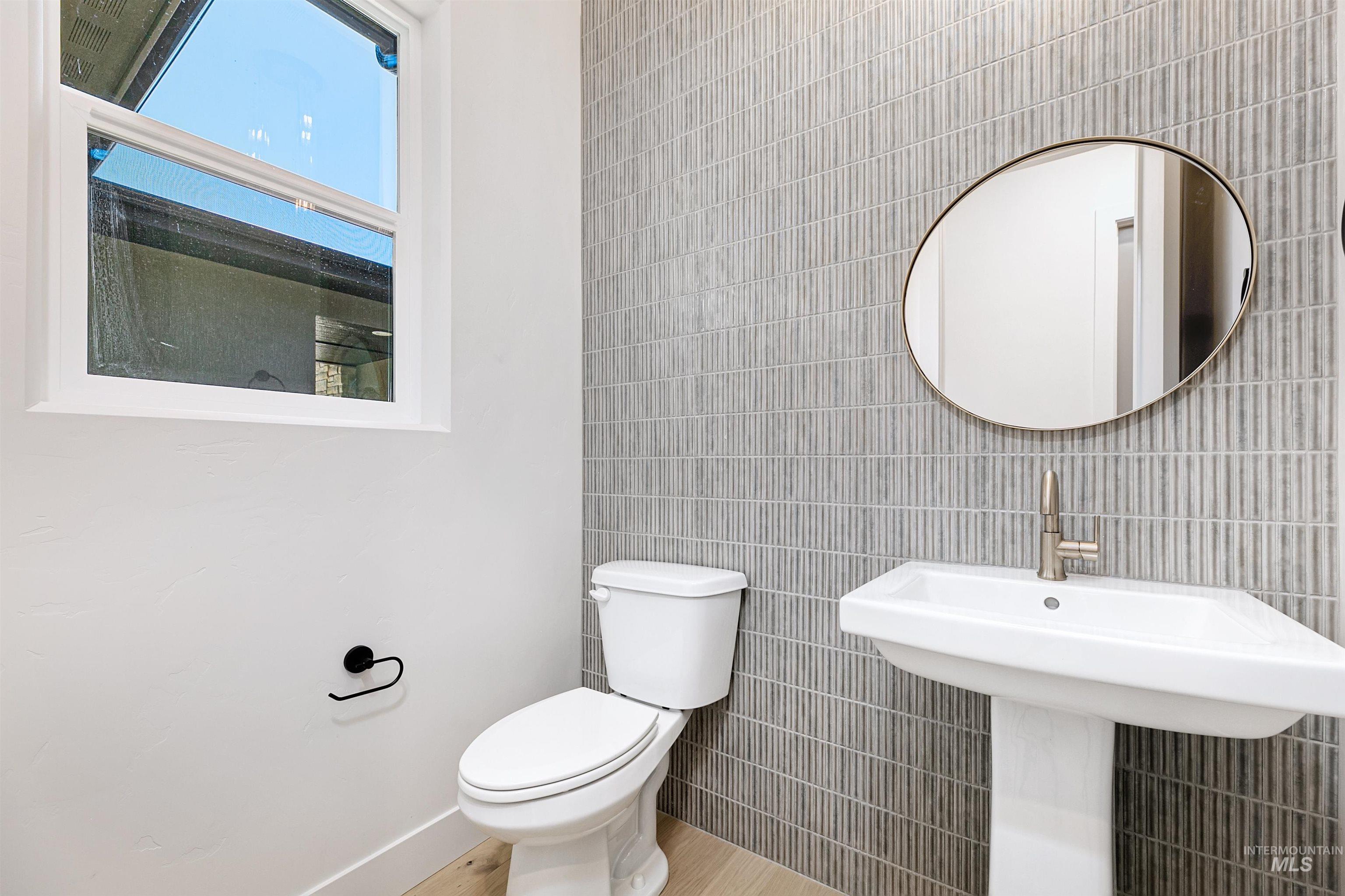 Bathroom featuring tile walls and wood finished floors