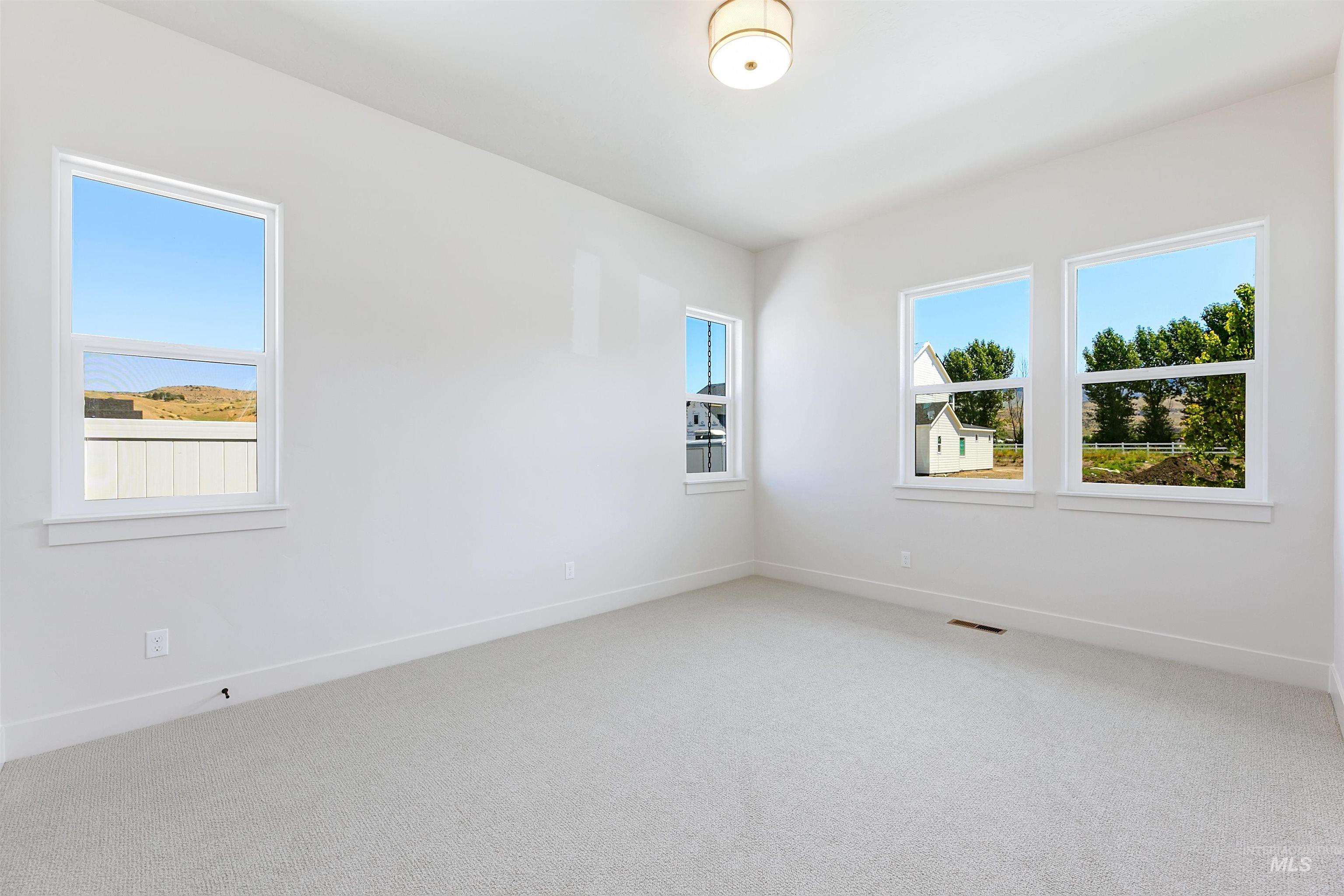Spare room with light carpet and baseboards
