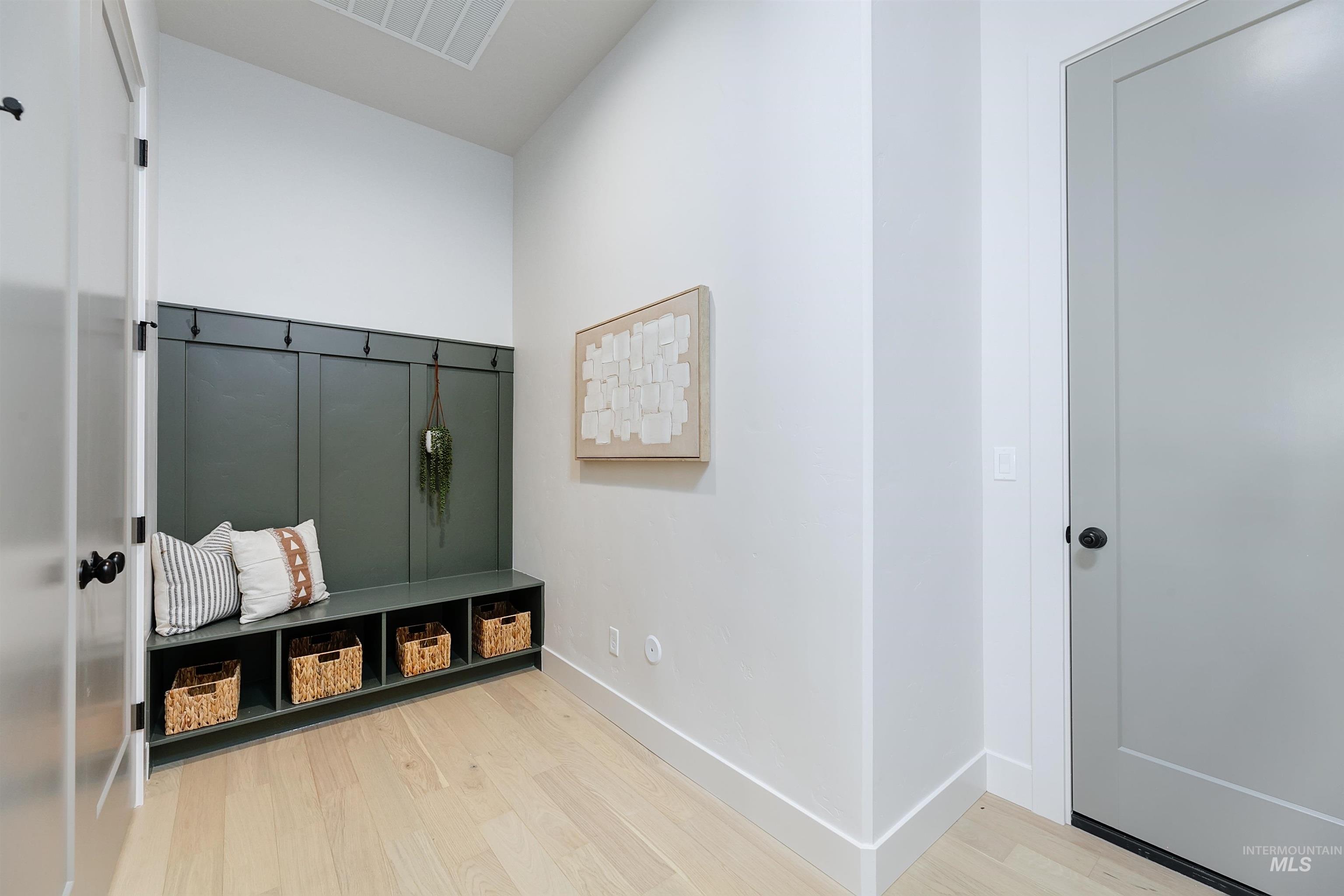 Mudroom with light wood finished floors and baseboards