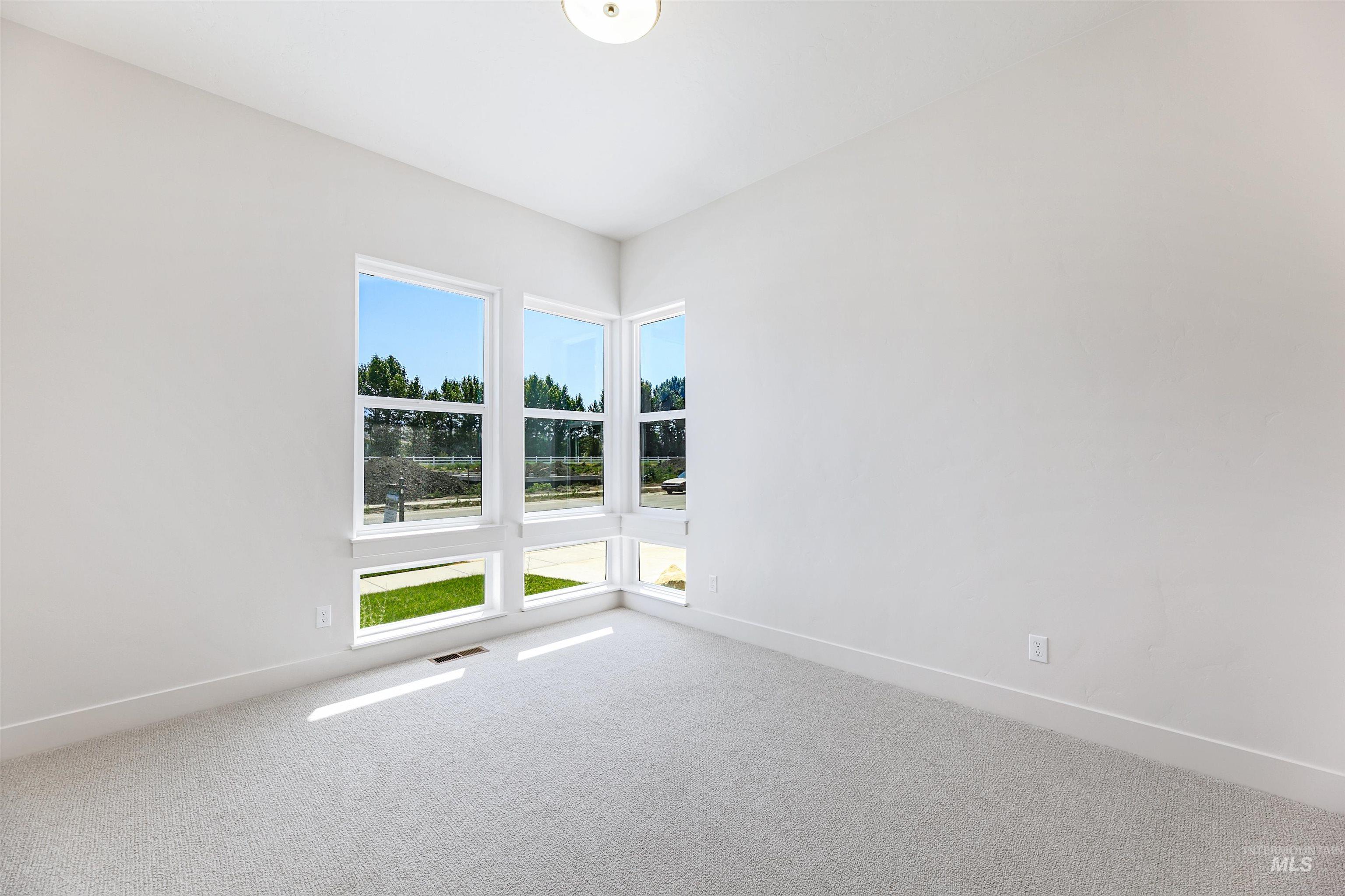 Carpeted empty room with healthy amount of natural light