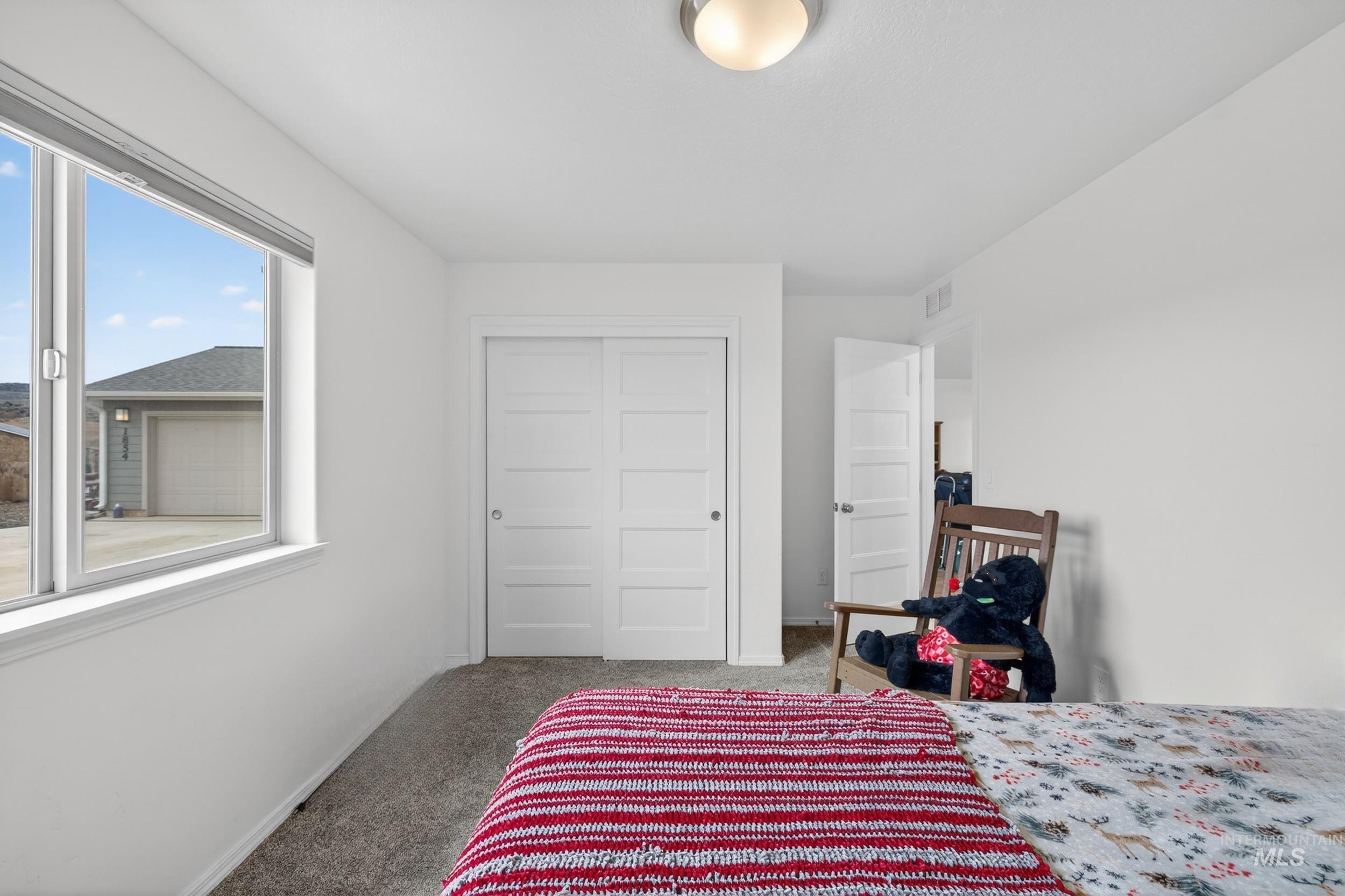 Bedroom featuring light colored carpet and a closet