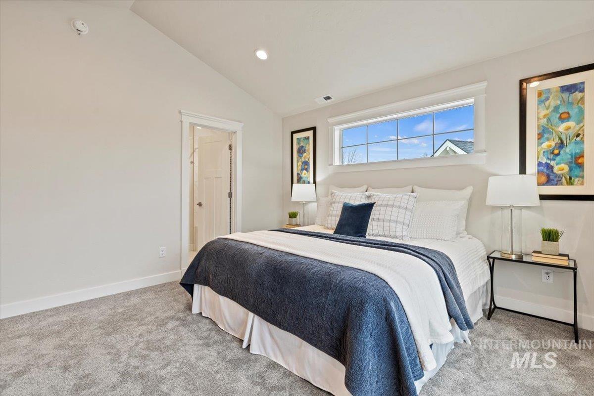 Bedroom with lofted ceiling, light colored carpet, and recessed lighting