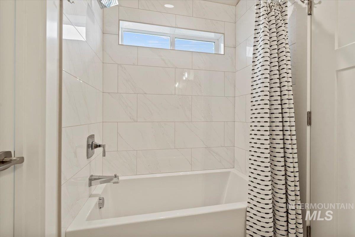 Bathroom featuring shower / tub combo with curtain