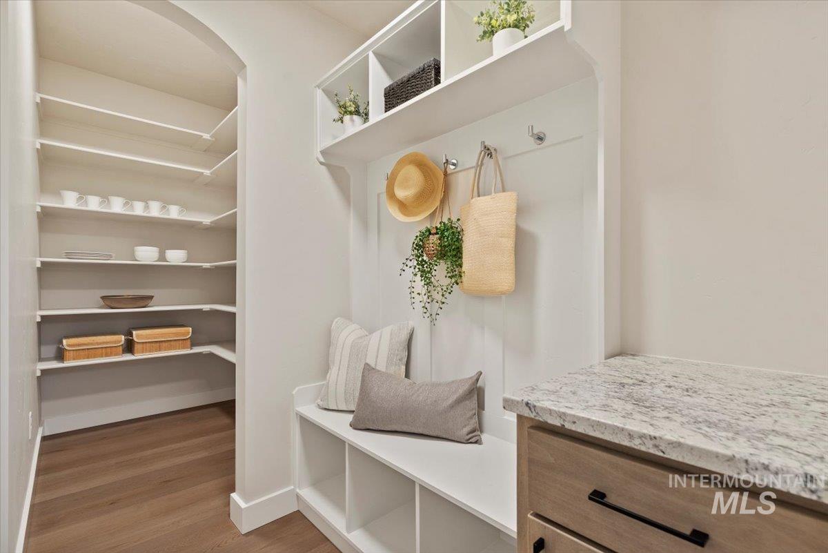Mudroom with wood finished floors and arched walkways