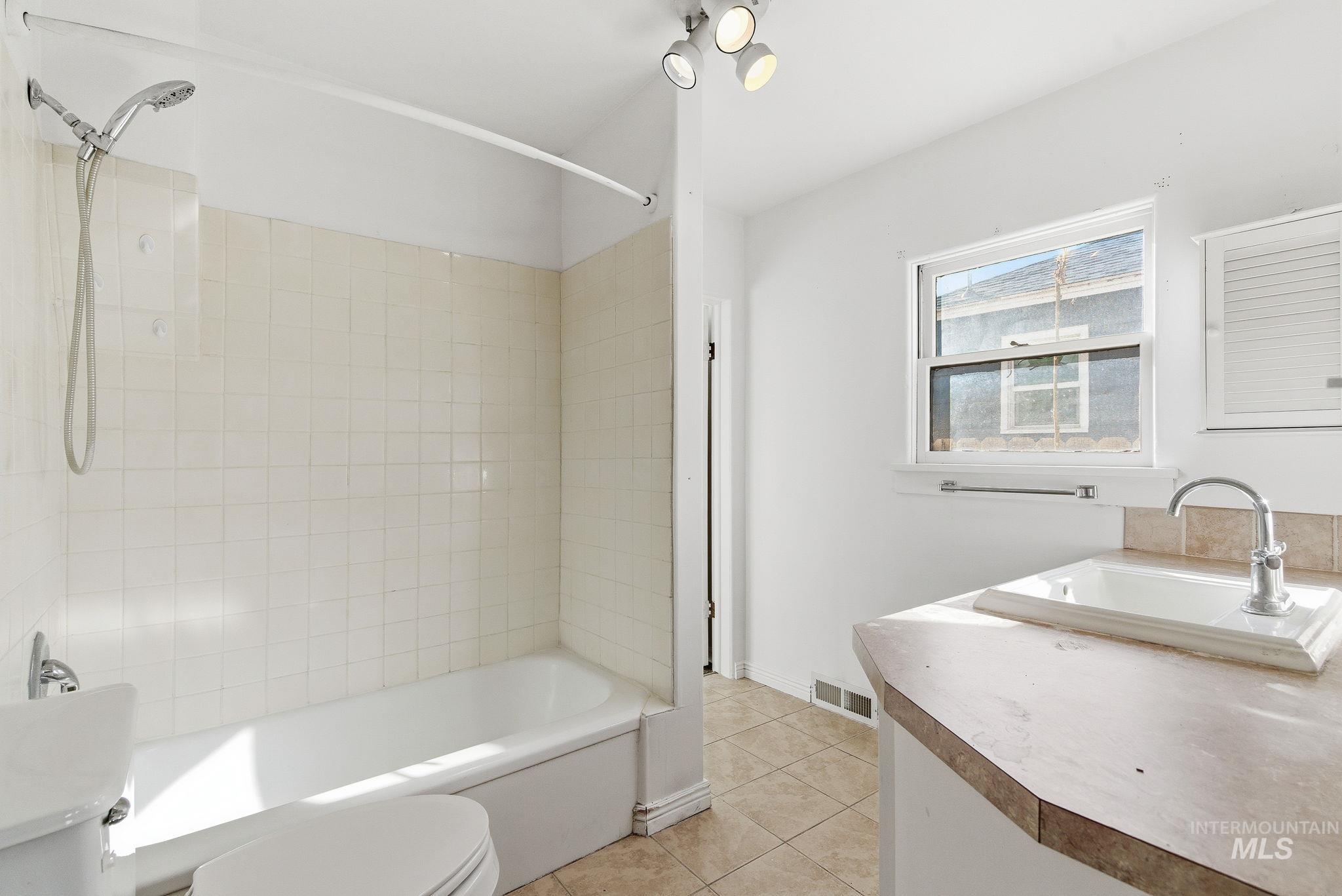 Full bath with vanity, tub / shower combination, and light tile patterned floors
