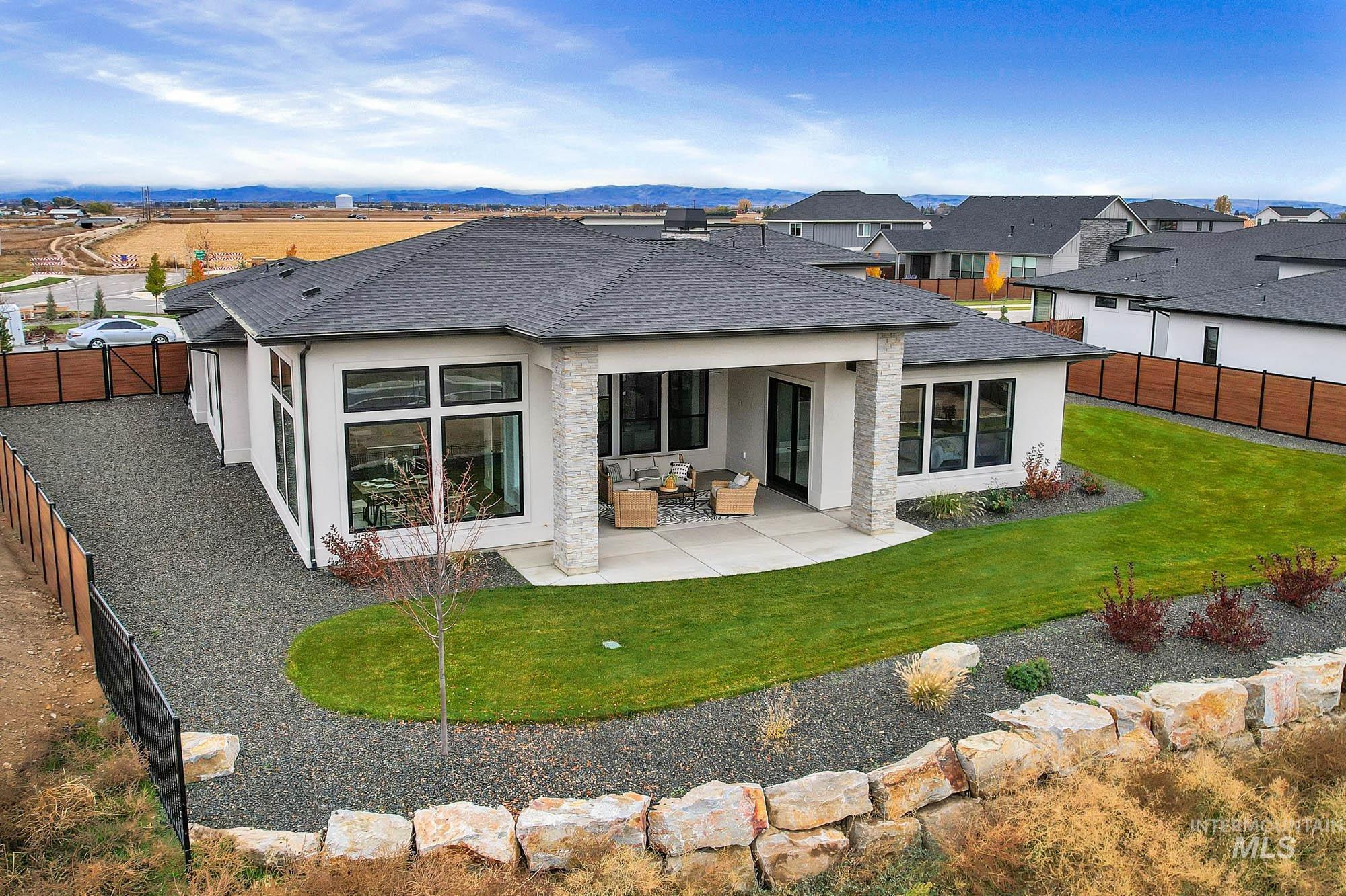 Rear view of property with roof with shingles, a fenced backyard, a patio area, stucco siding, and an outdoor living space