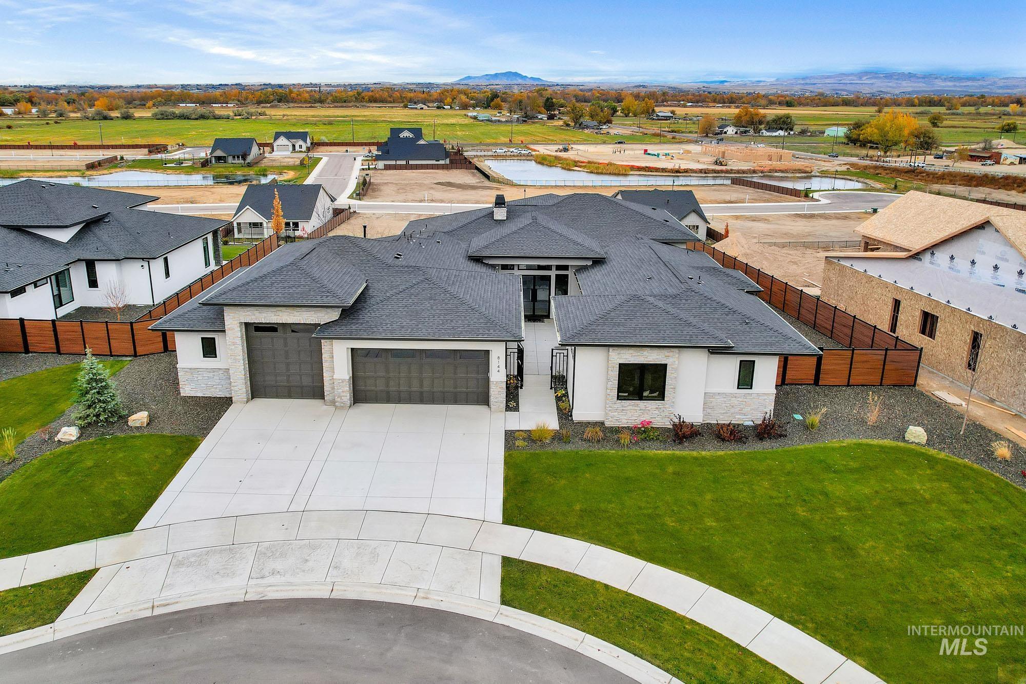 View of front of home featuring stone siding, a shingled roof, a garage, and concrete driveway