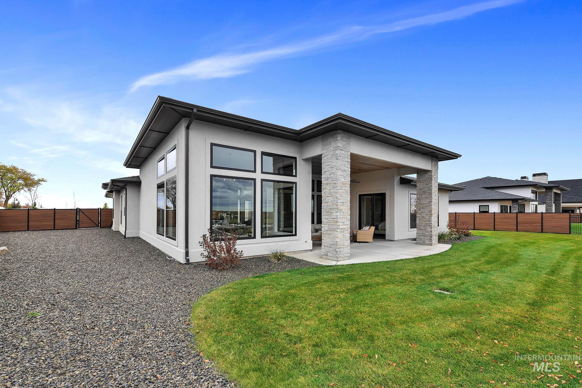 Rear view of house featuring a fenced backyard, stucco siding, and a patio