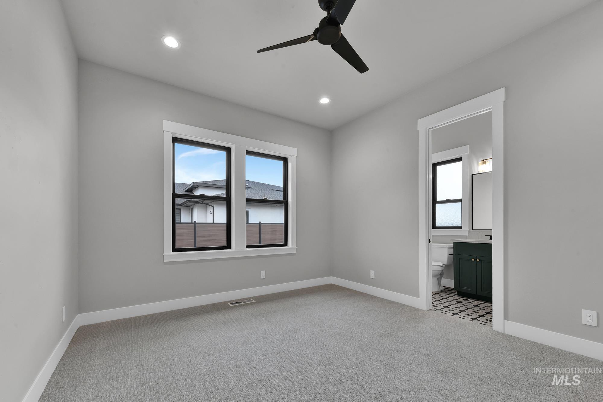 Unfurnished bedroom with light carpet, multiple windows, recessed lighting, and a ceiling fan