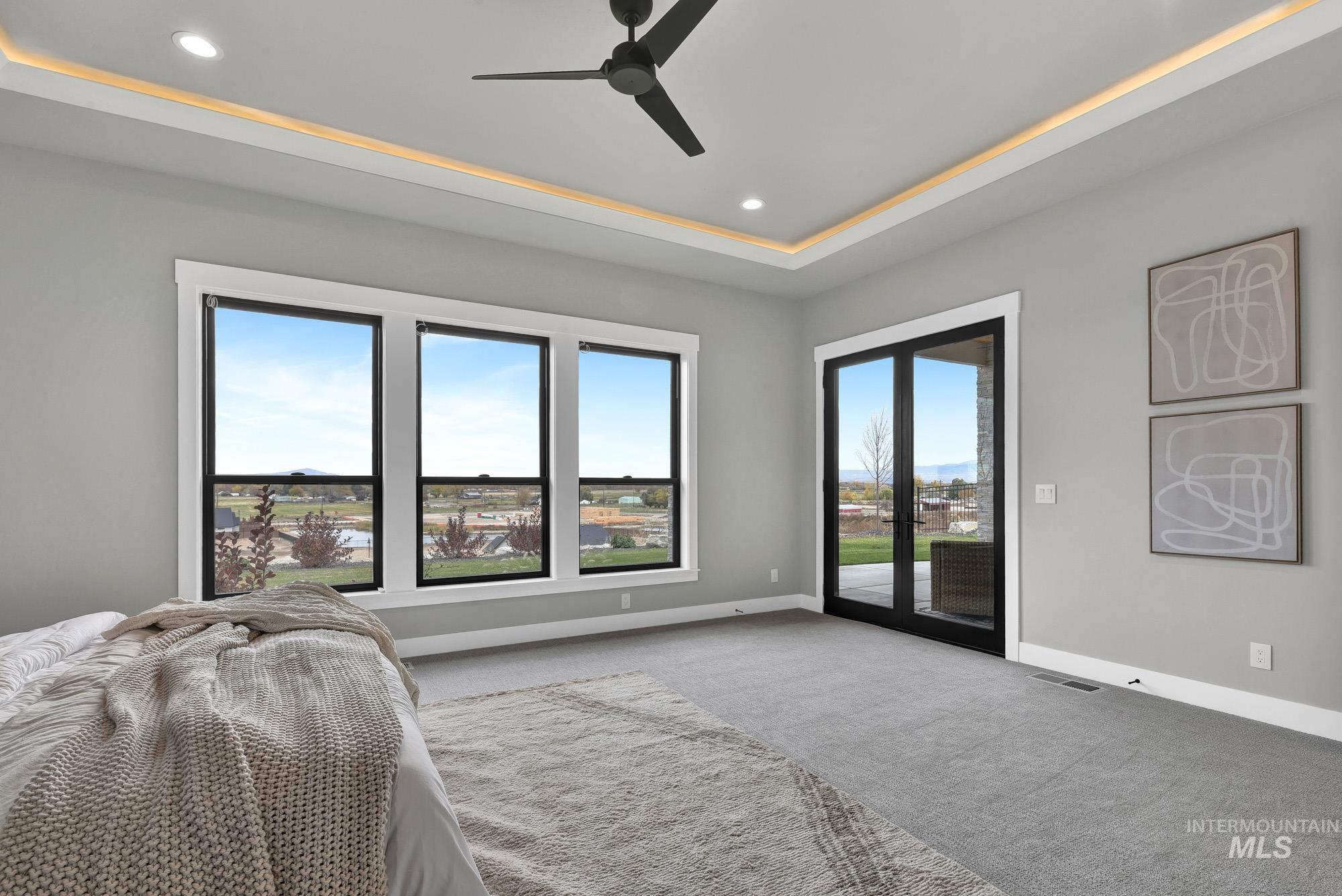 Carpeted bedroom featuring a tray ceiling, access to outside, a ceiling fan, and recessed lighting