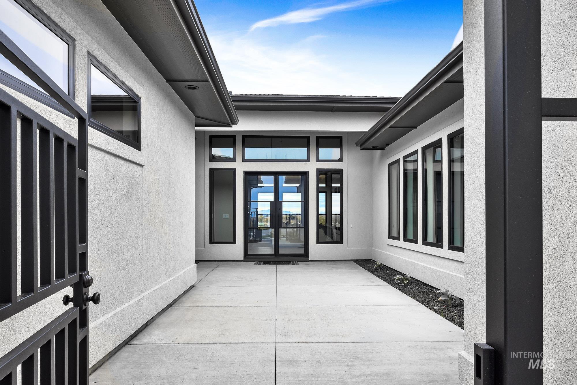 Doorway to property featuring stucco siding and a patio area
